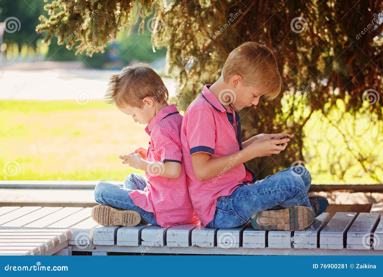 Dois Rapazes Pequenos Que Jogam Jogos No Telefone Celular No Dia  Ensolarado, Sitt Imagem de Stock - Imagem de tecnologia, mensagem: 76900281