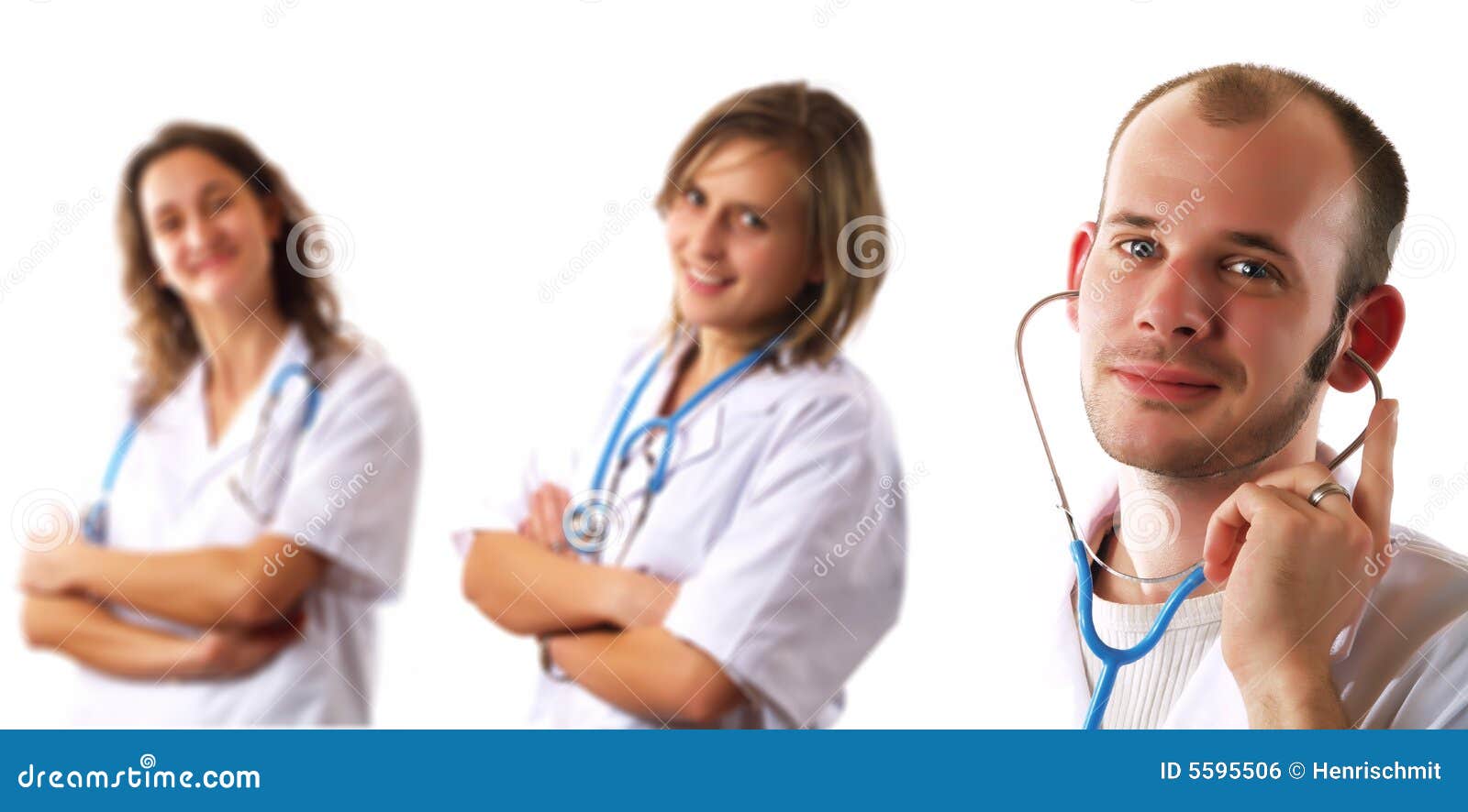 Doktorteam. Ein attraktiver Doktor und zwei hübsche Damedoktoren lächeln. Sie haben Stethoskope und sie tragen weiße Mäntel.