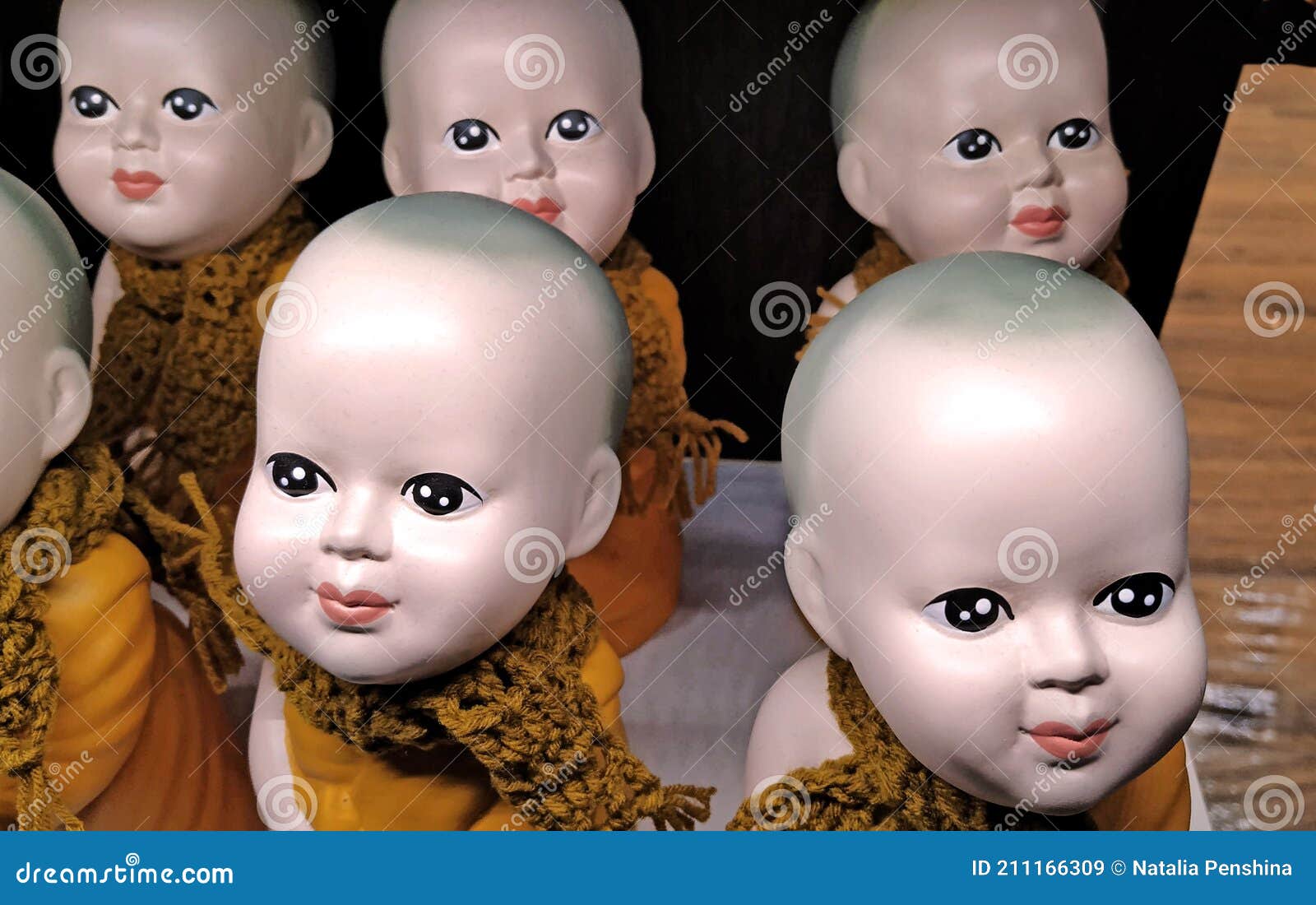 Doll Figures, with Big Eyes, No Hair on Their Heads, Dressed in Orange Monk  Clothes and Knitted Scarves. Stock Image - Image of head, grimace: 211166309