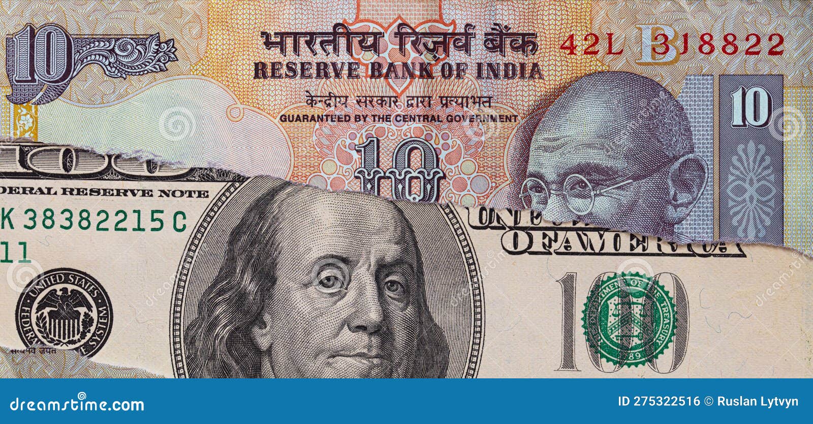 100 Dollar Banknote through Torn Indian Rupee Banknote Stock Photo