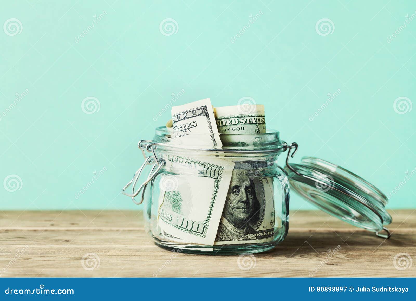 dollar bills in glass jar on wooden table. saving money concept.