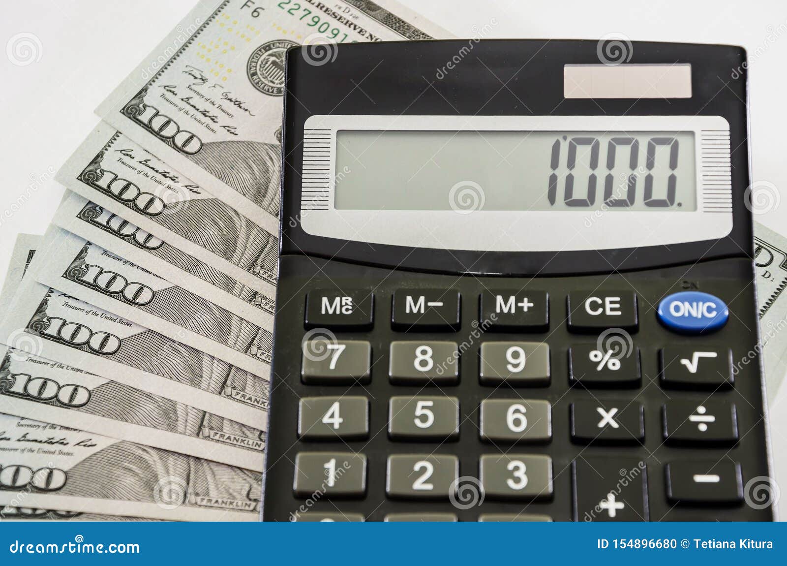 Dollars and Calculator on a White Background, Closeup. Stock Photo