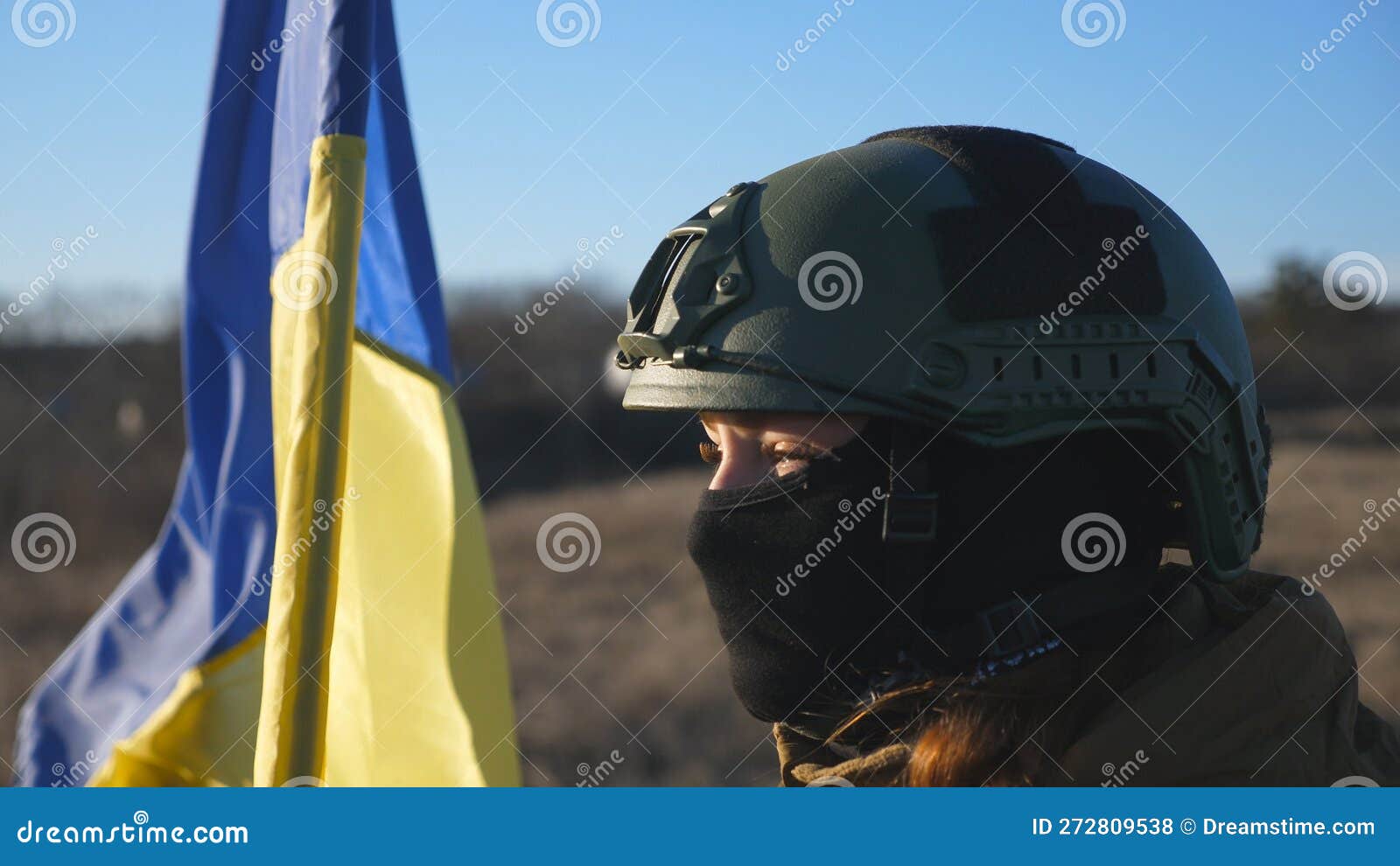 Dolly Shot of Girl in Military Helmet and Balaclava Holds a Waving ...