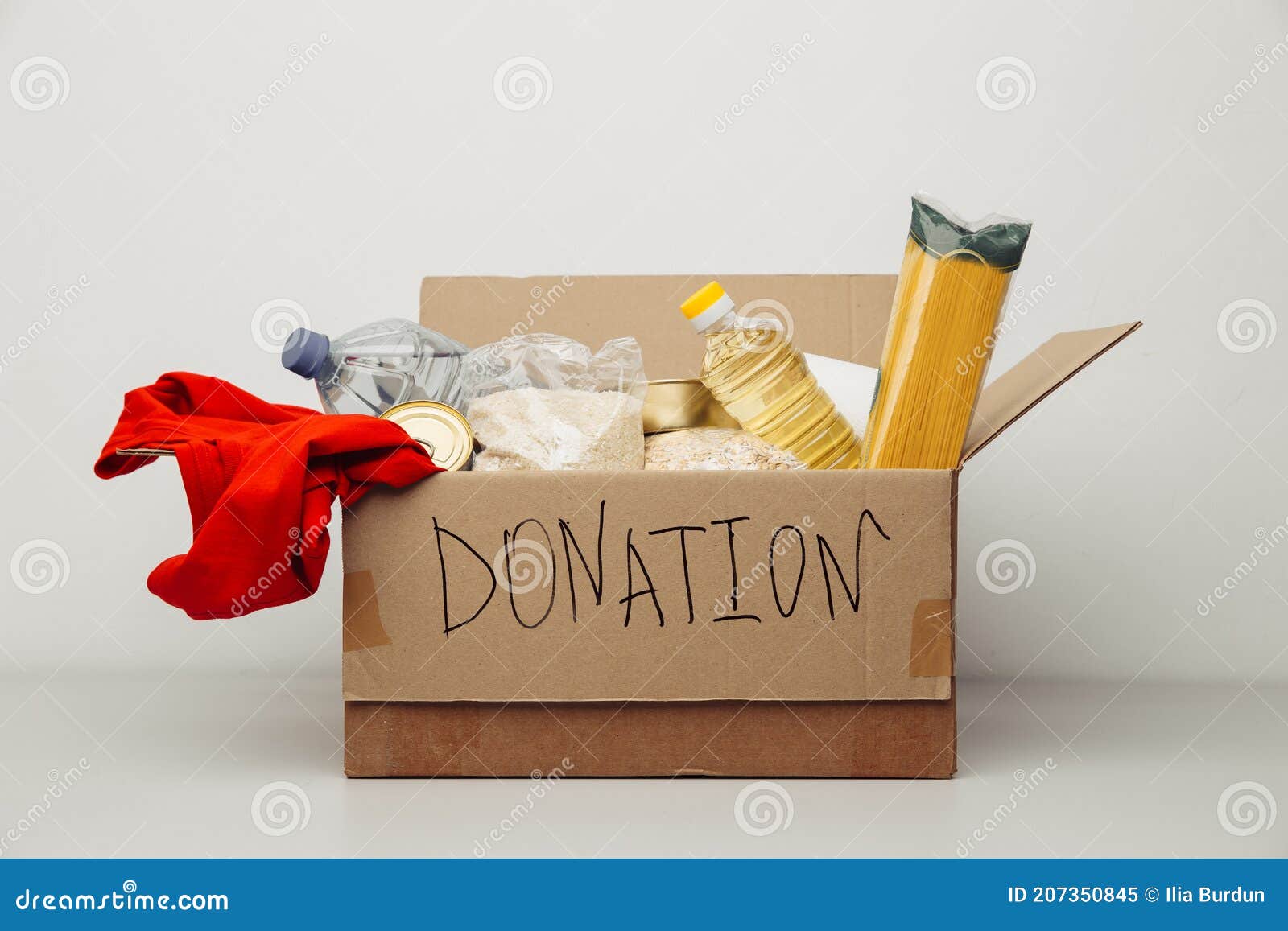Donation Box. Open Cardboard Box with Clothes and Food Stock Image
