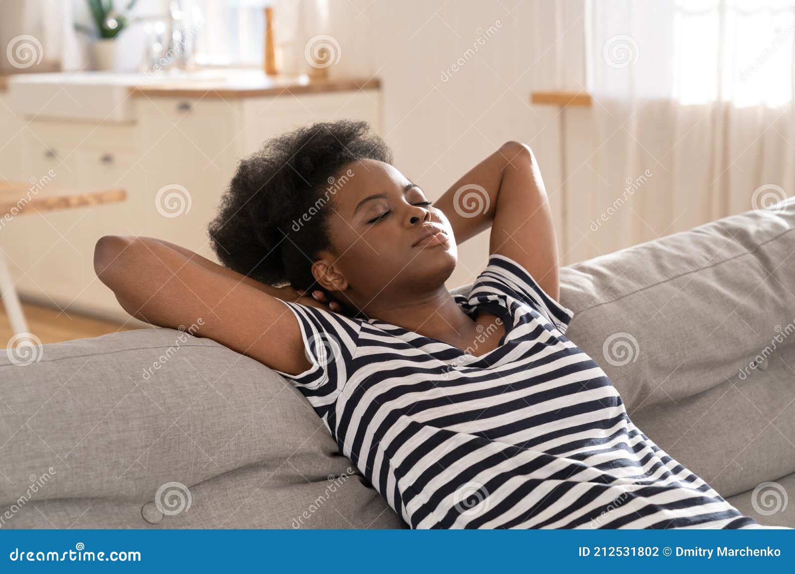 Donna Afro - Americana Indossa Una Maglietta Spogliata Che Dorme Sul Divano  Con Un Braccio Sotto La Testa a Casa. Riposo. Fotografia Stock - Immagine  di giorno, femmina: 212531802