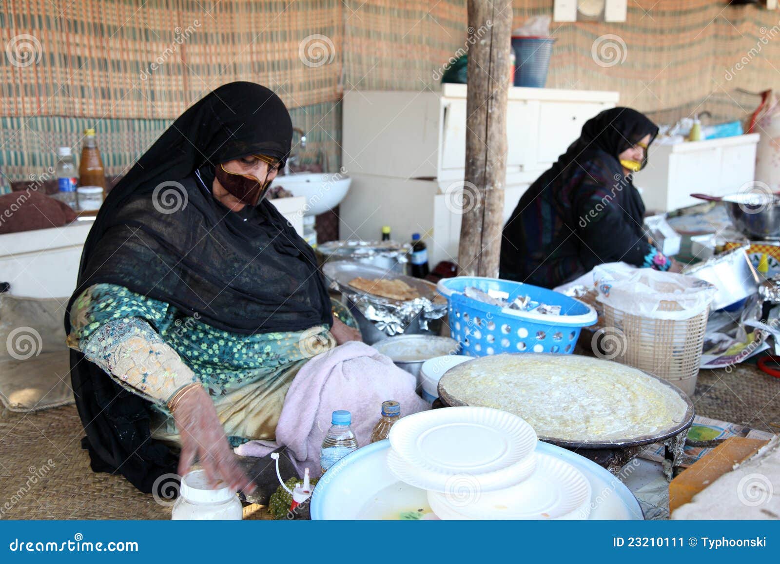 Donna araba con la maschera di protezione tradizionale che vende alimento al villaggio di eredità della Doubai. Foto catturata al diciottesima del gennaio 2012