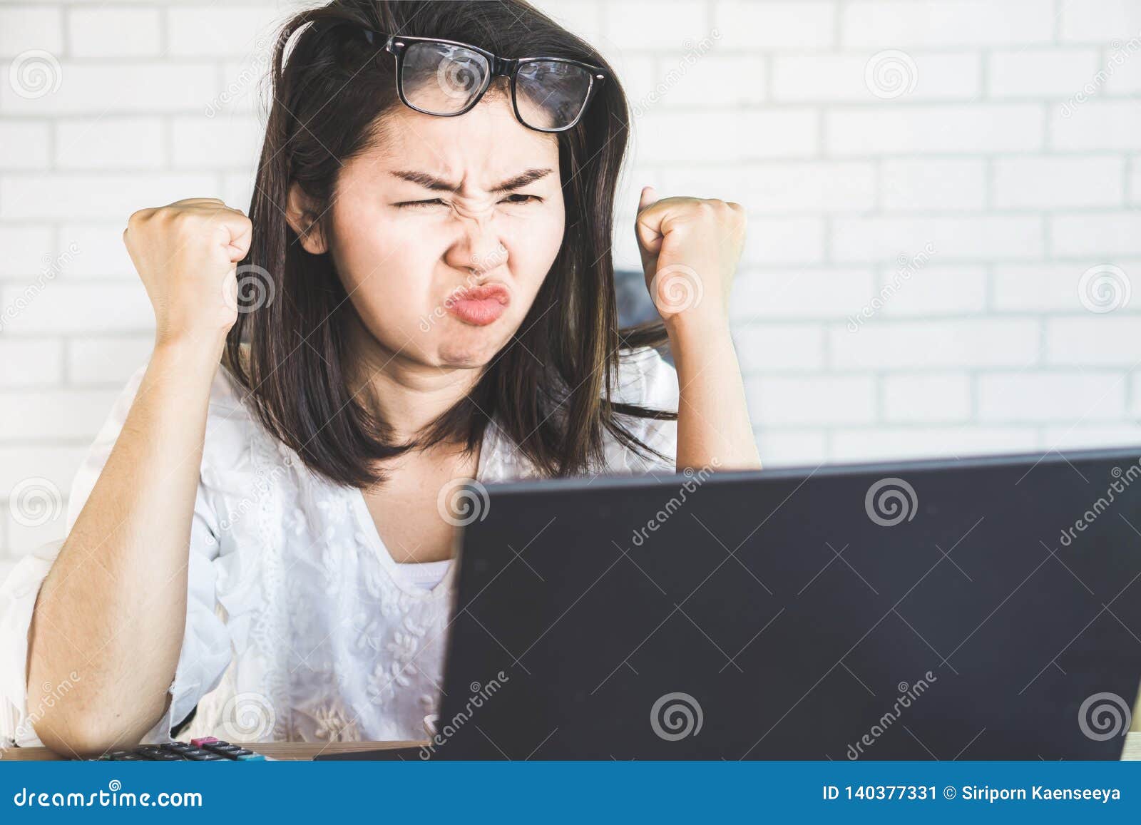 Donna asiatica arrabbiata di affari che lavora e pazza al computer portatile del computer, concetto infelice del lavoratore