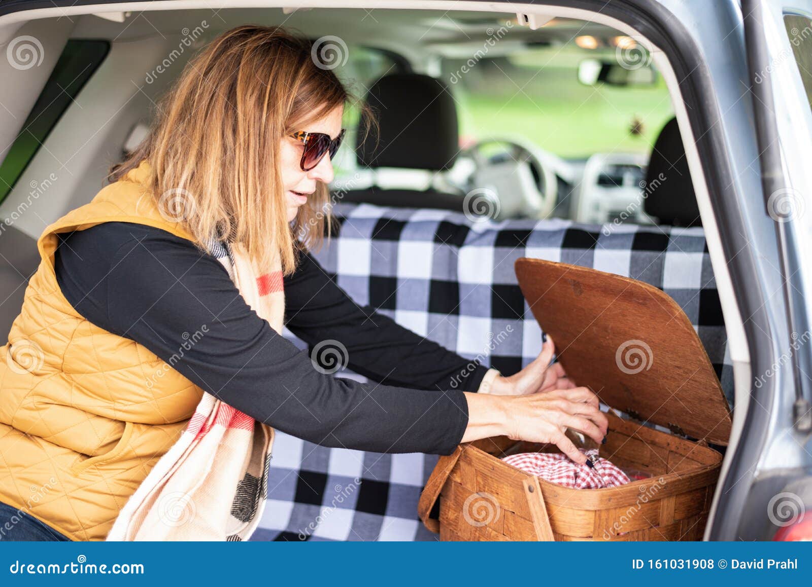 Donna Che Apre Un Cestino Da Picnic Sul Retro Dell'auto Fotografia