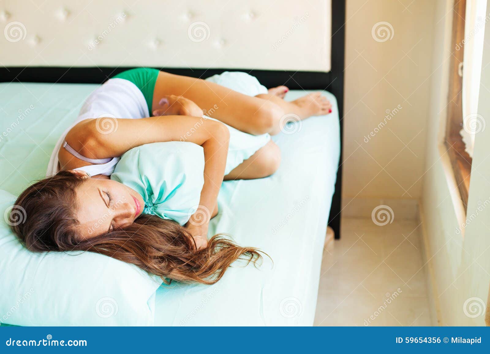 Donna Che Dorme Con Il Cuscino Lungo Fotografia Stock - Immagine di  menzogne, materasso: 59654356