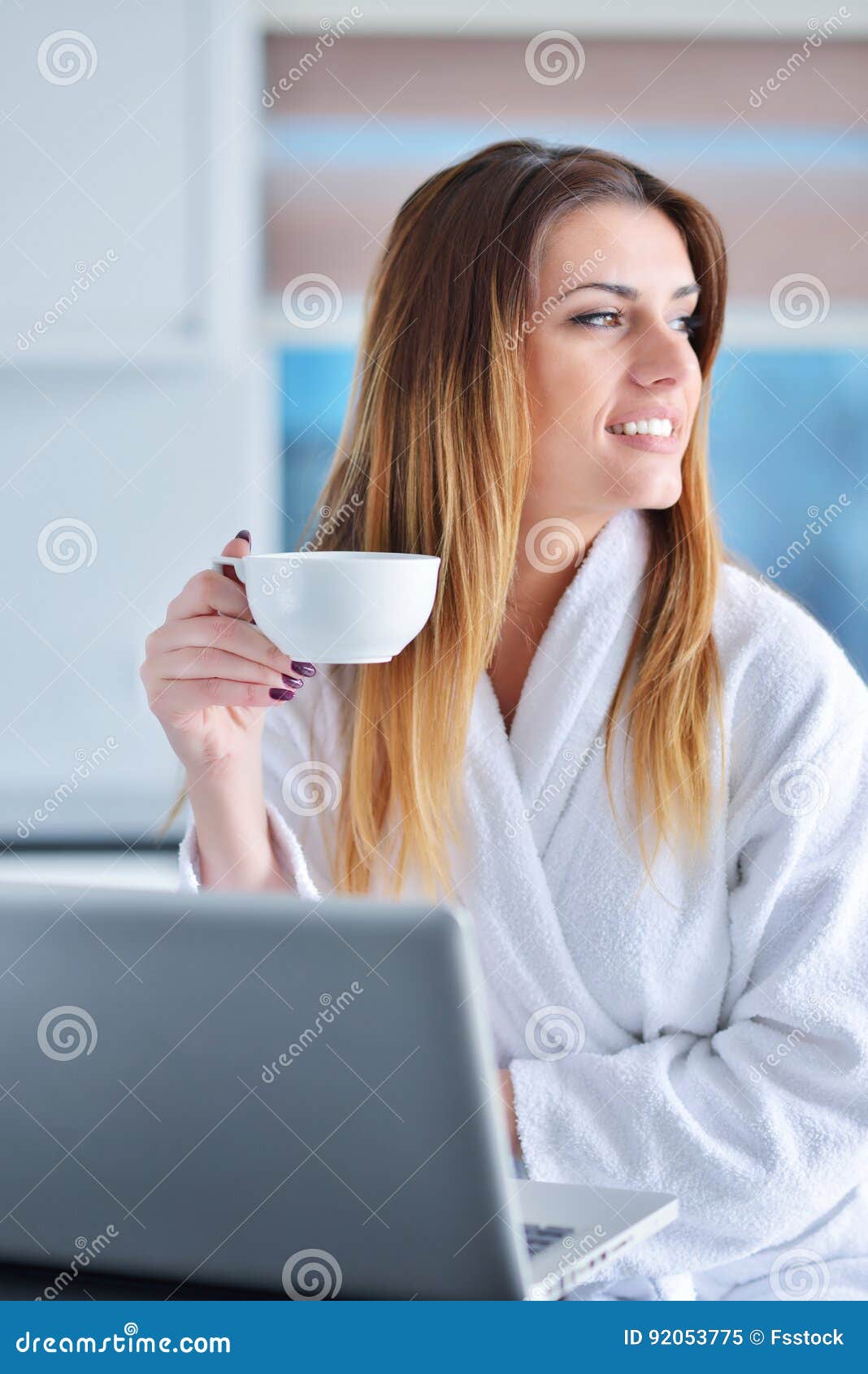 Donna felice nella lettura della cucina lui notizie sul suo computer portatile