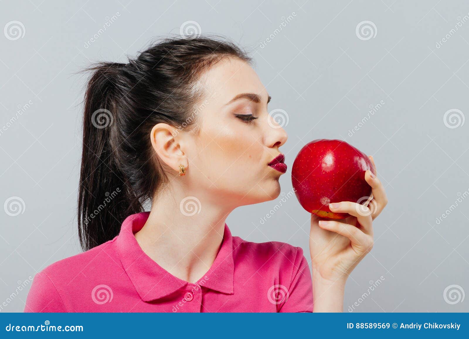 Сон есть красное яблоко. Яблоко надкушенное в виде женщины. Девушка откусывает яблоко. Симпатичная девушка откусывает яблоко. Она ест яблоко.
