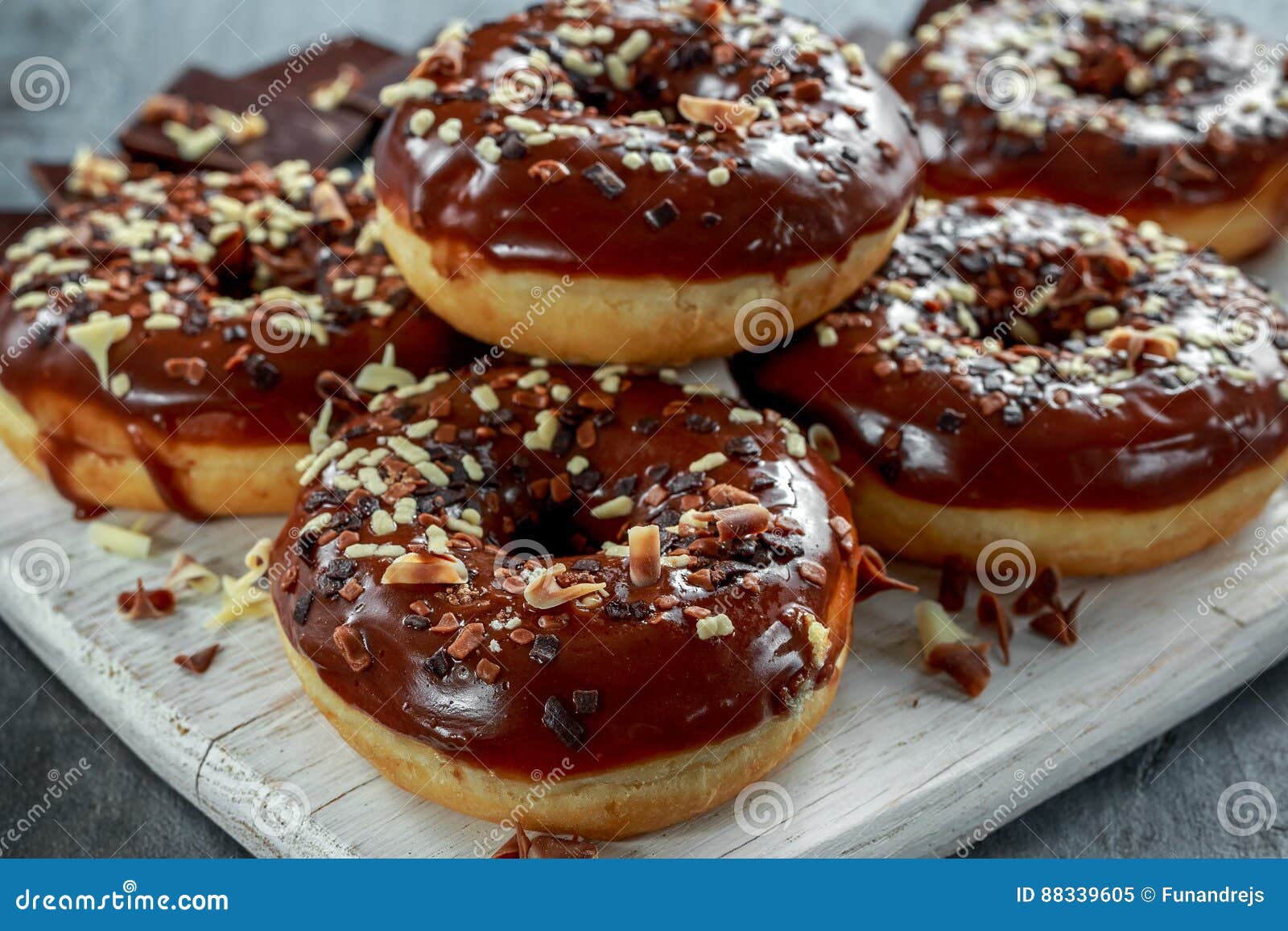 Donut Rings with White and Dark Chocolate Chippings and Icing Served on Board Stock Image