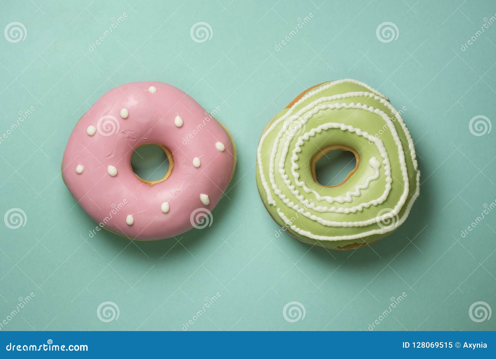 donuts on turquose background with green, pink icing and white sugar decorations