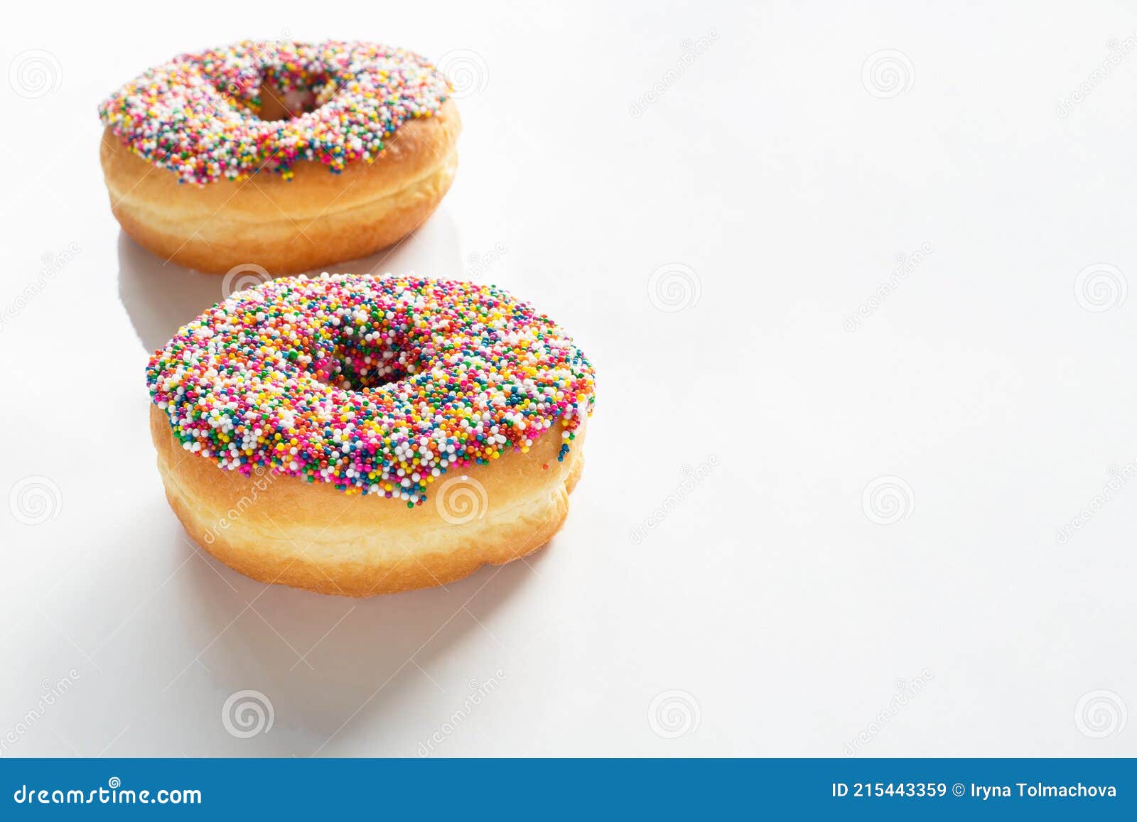 donuts with colorful sprinkles on white background with copy space