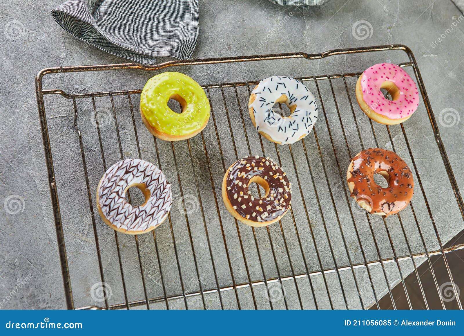 Donuts Multicolores Con Vidrios Y Rociadores Sobre Un Soporte De Metal Del  Horno Y Una Servilleta Gris Imagen de archivo - Imagen de pasteles,  esmaltado: 211056085