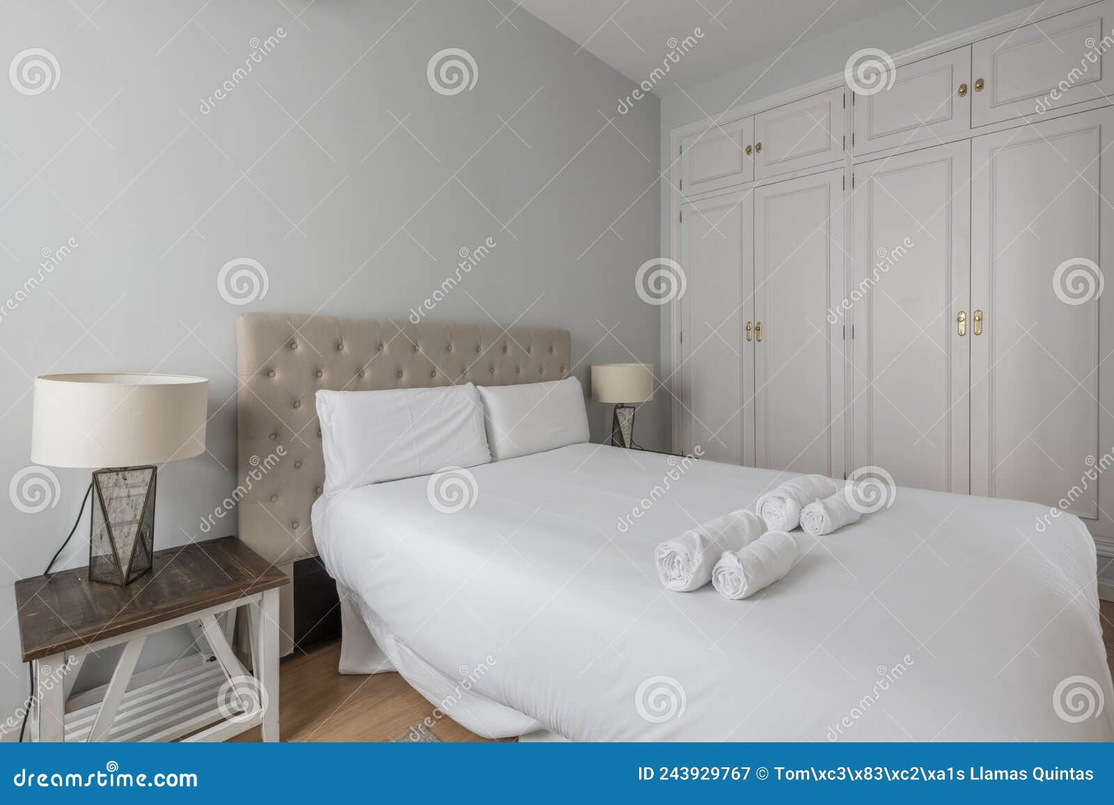 Cojines en blanco grande cama antigua con detalles tallados en dormitorio  con empapelado y mesillas de noche Fotografía de stock - Alamy