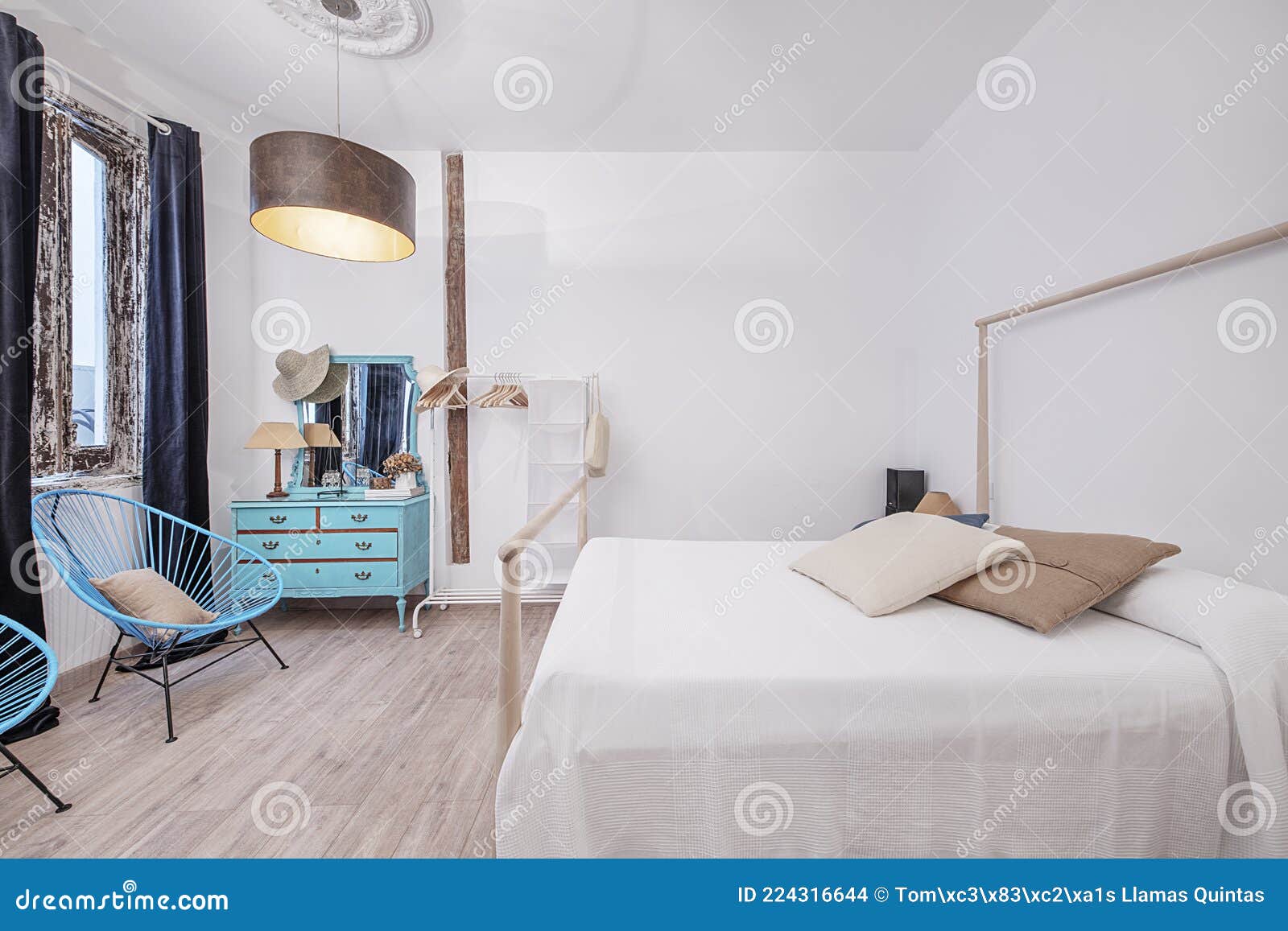 bedroom in vacation apartment with blue dresser and blue armchairs.