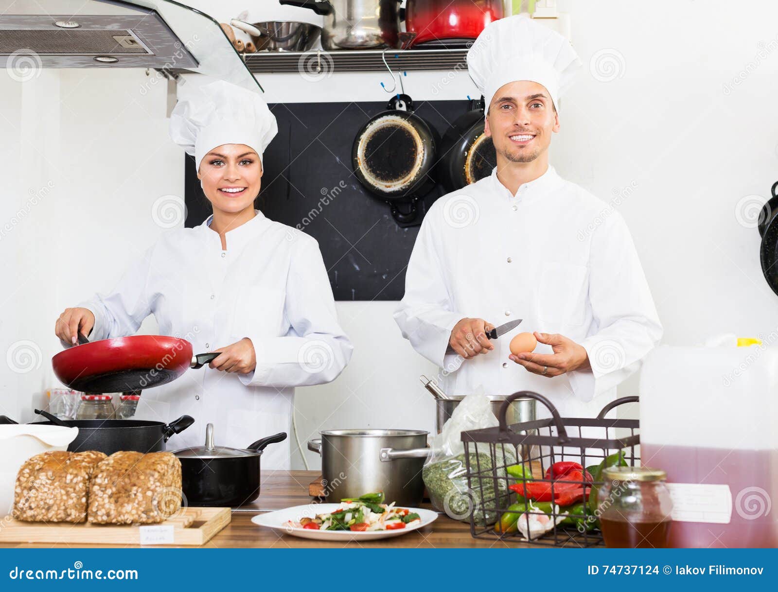 dos-cocineros-que-cocinan-la-comida-74737124.jpg