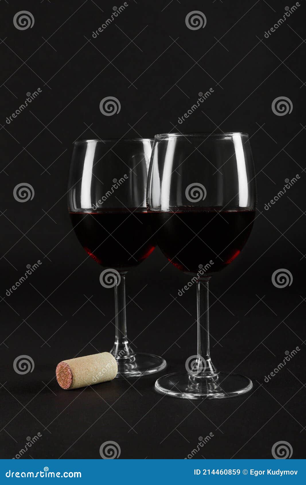 Dos copas con vino tinto y corcho en una