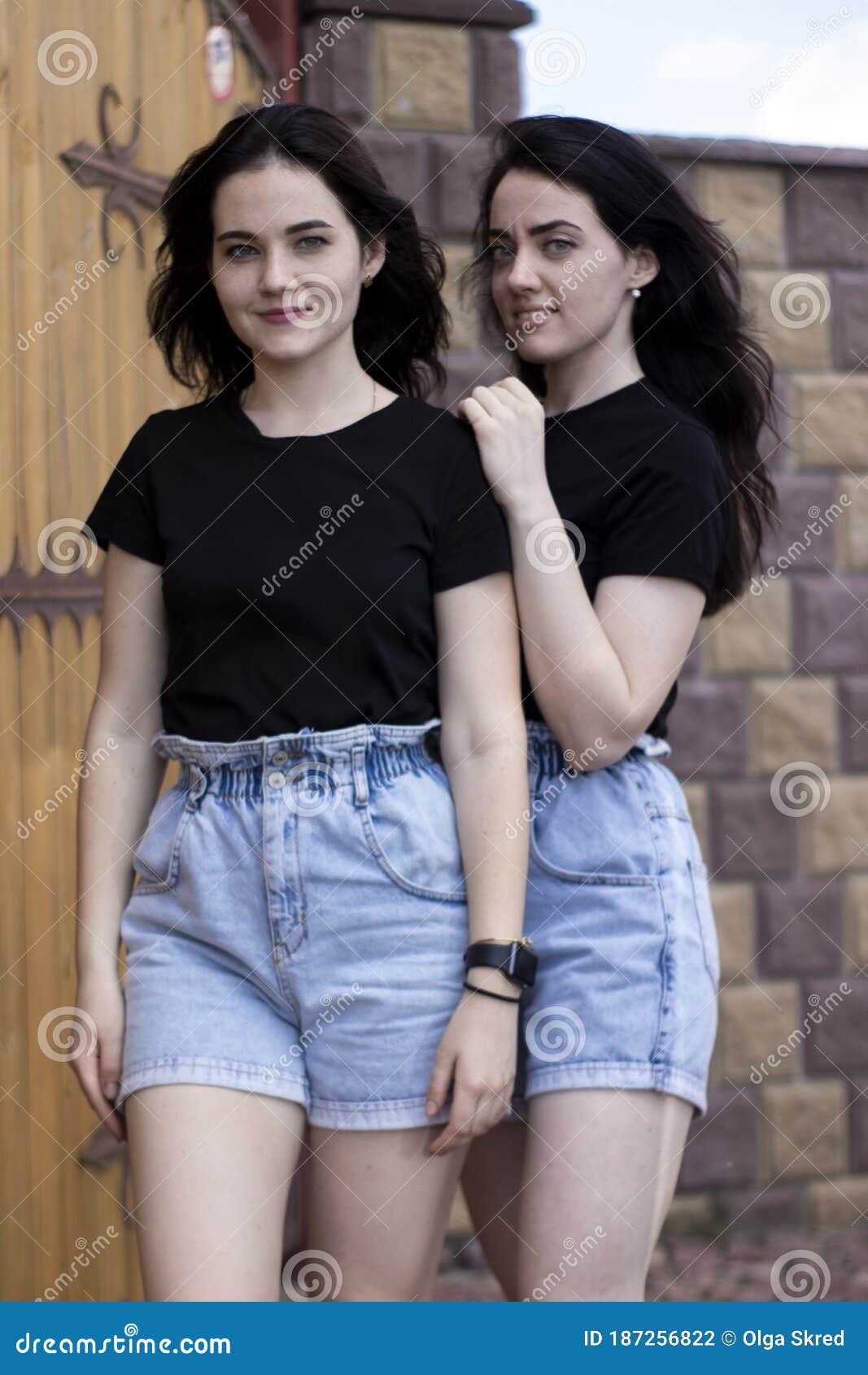 Dos Jóvenes Morenas Con Una Camiseta Negra Y Pantalones Cortos De Denim Abrazándose Hermanas 