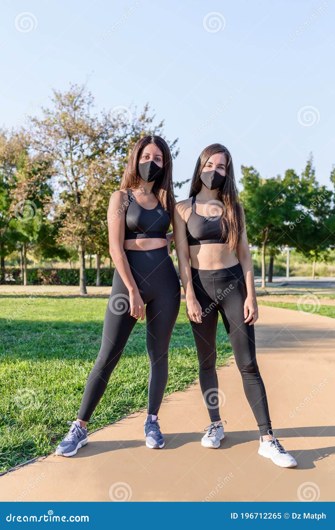 Dos Mujeres Con Ropa Deportiva Y Máscara Negra Posando Para Una Foto En Un  Parque Verde Imagen de archivo - Imagen de amistad, oscuro: 196712265