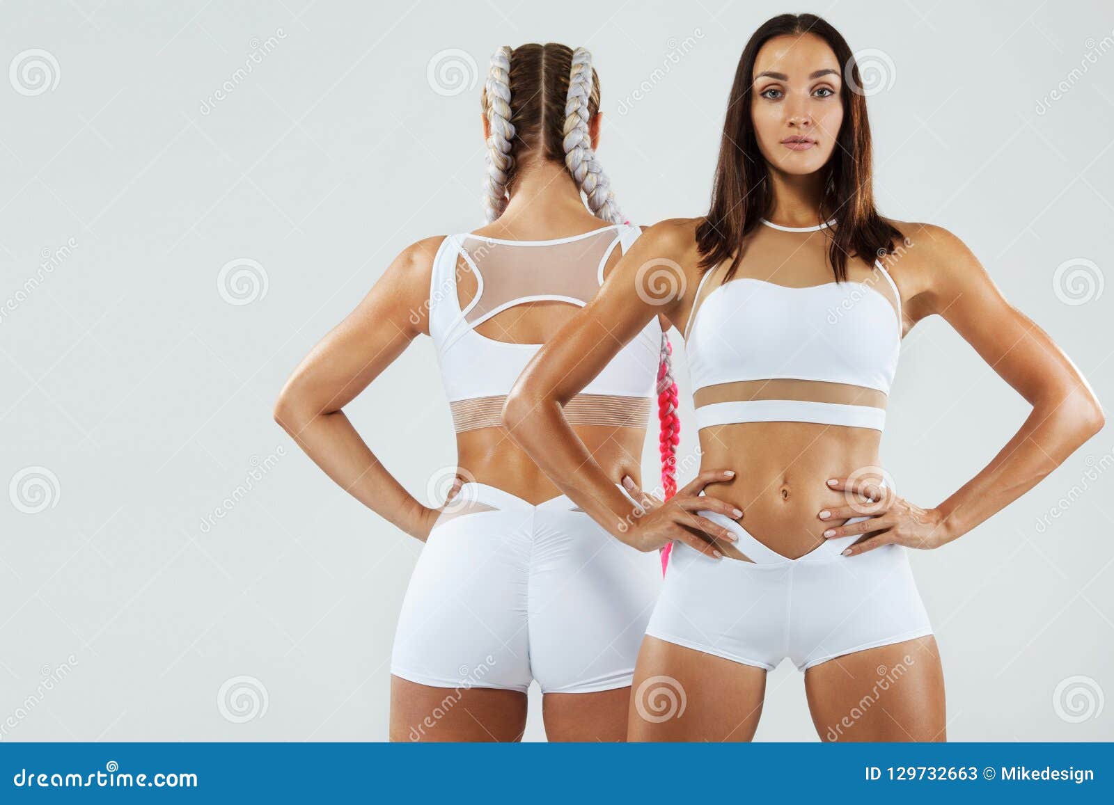 Dos Mujeres Del Atletismo De La Aptitud En La Ropa De Deportes Aislada En  El Fondo Blanco Concepto Del Deporte Y De La Moda Con E Imagen de archivo -  Imagen de