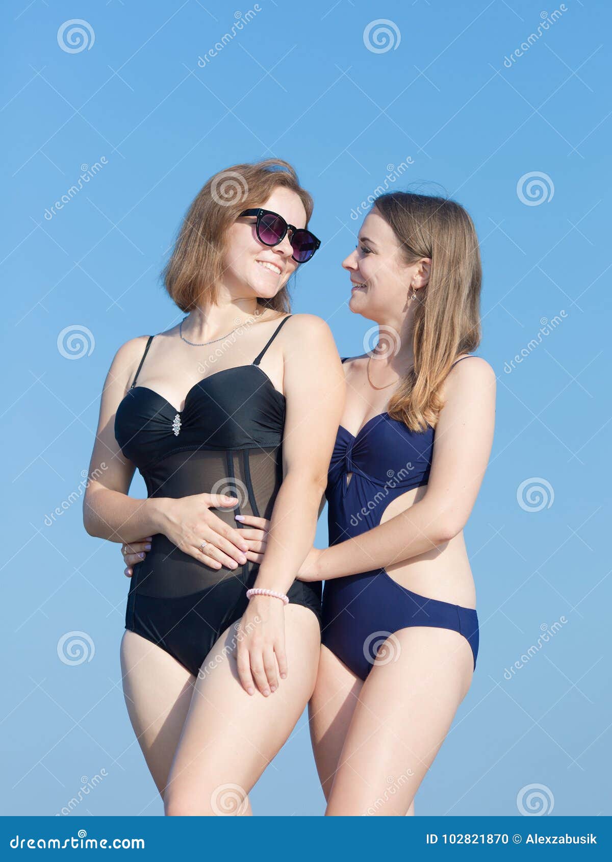 Dos Mujeres Jovenes Atractivas En Trajes De Baño Contra El Cielo Foto de  archivo - Imagen de amistad, standing: 102821870