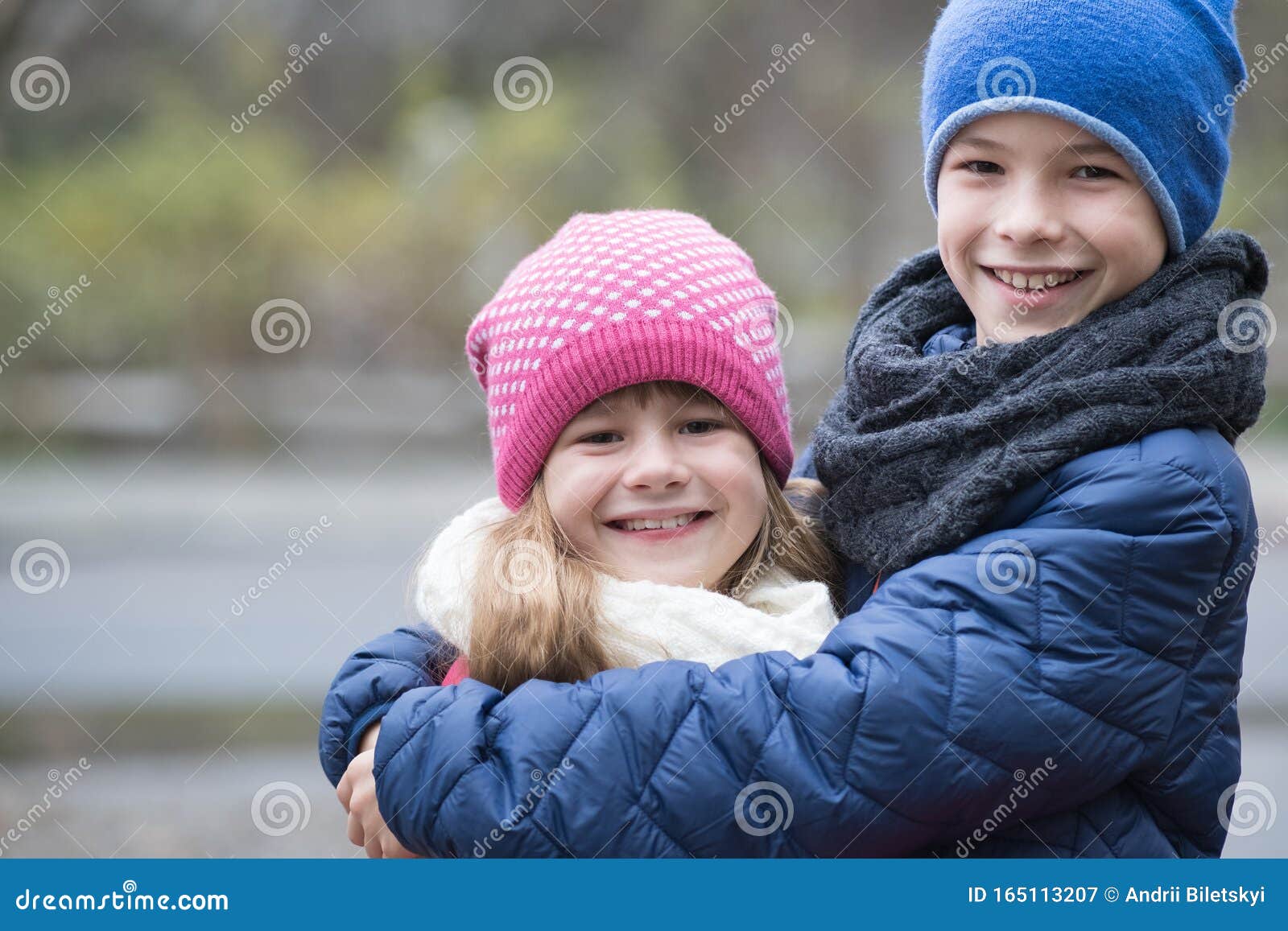 Dos Niños Y Niñas Se Abrazan Al Aire Libre Con Ropa Abrigada En Otoño Frío  O Invierno Imagen de archivo - Imagen de manera, adorable: 165113207