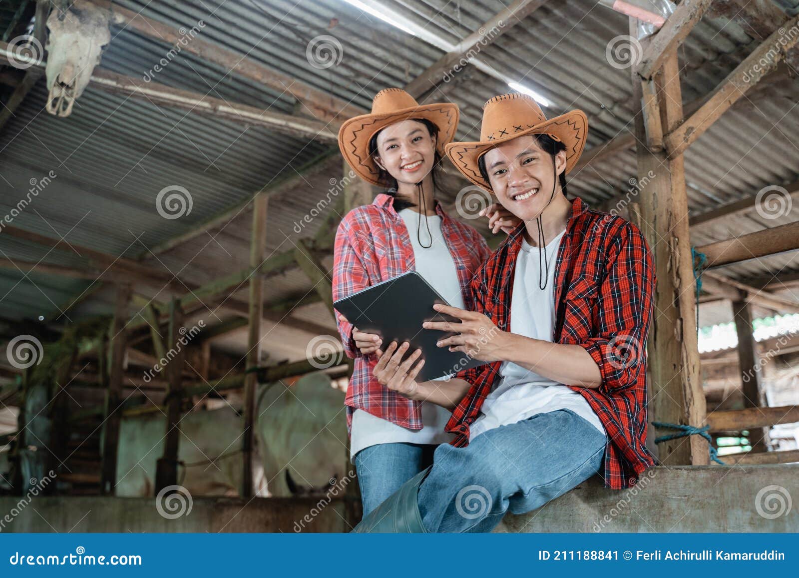 Dos Sonrientes Agricultores Con Ropa Casual Se Sientan Junto a Una Valla De  Madera Mientras Utilizan Una Tableta Digital Imagen de archivo - Imagen de  granero, establo: 211188841