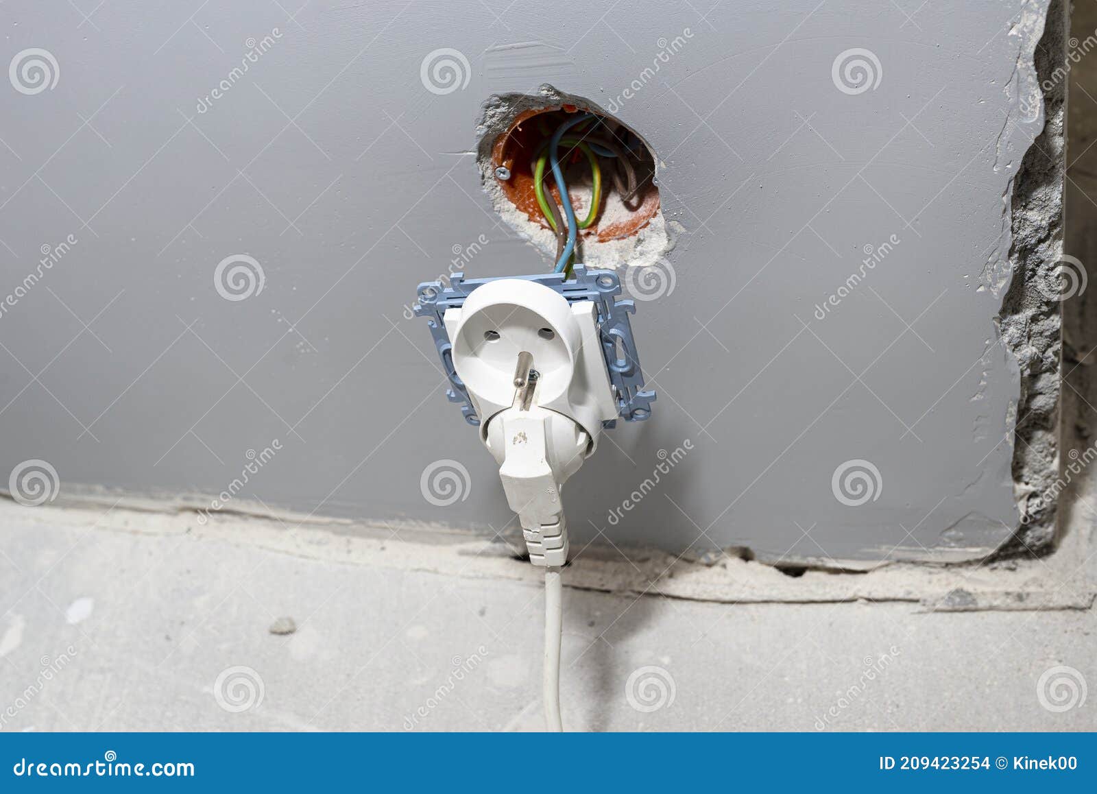 Double Electric Socket Protruding from the Wall, Holding on To Electric Cables. Stock Photo