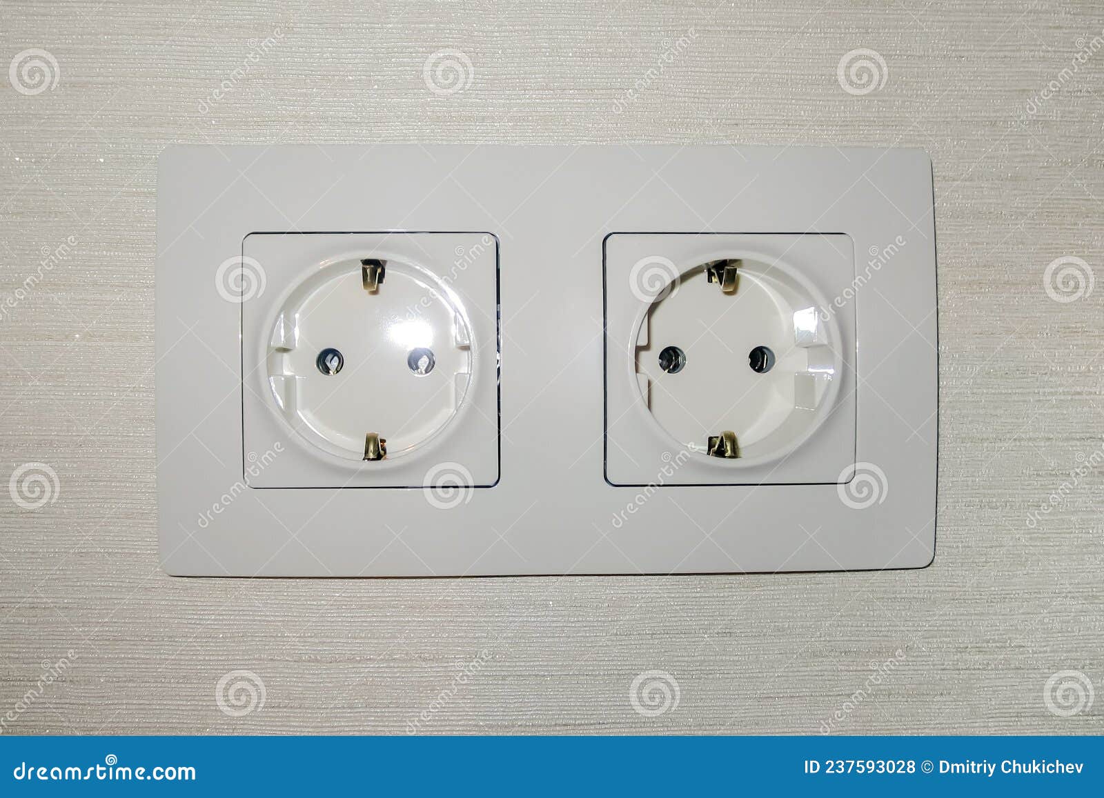 Double Electrical Outlet on the Wall with Wallpaper. the Color is Ivory
