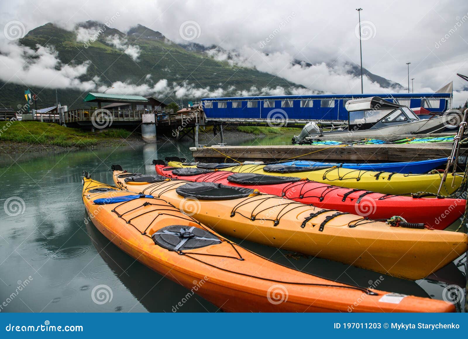 double kayaks parked on the pier on scenic mountain ocean bay in valdez, alaska.