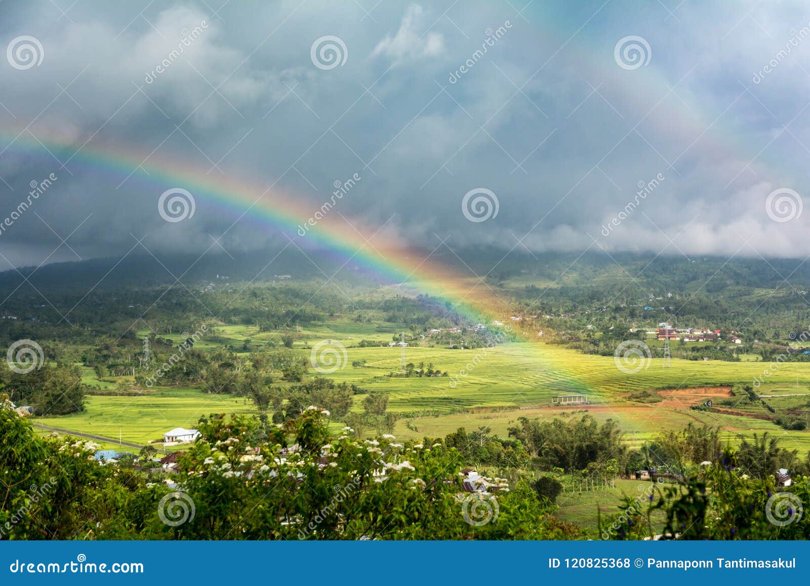 double rainbow over countryside with a storm background. ruteng, manggarai regency, flores, east nusa tenggara, indonesia
