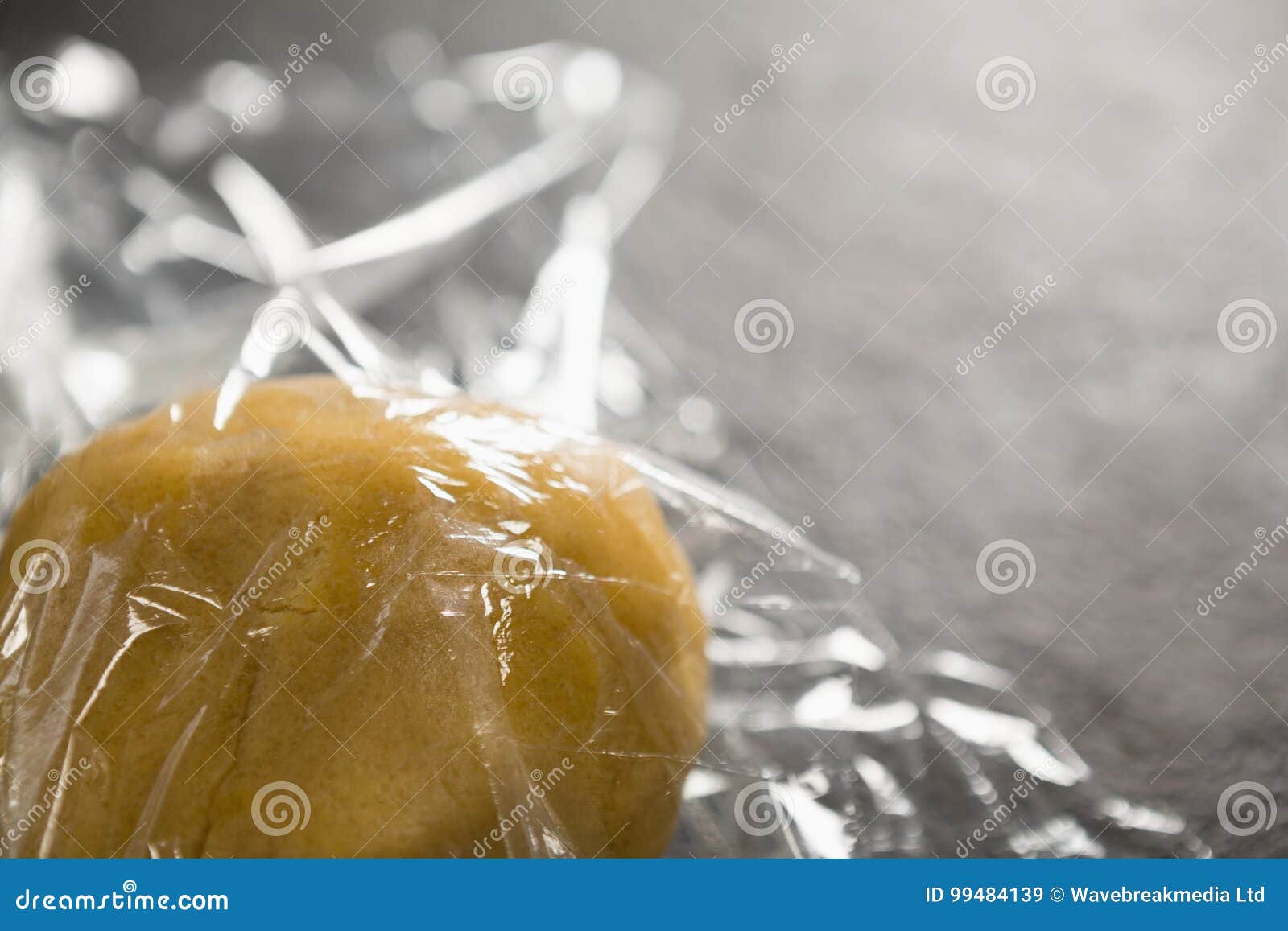 Dough in plastic wrap stock image. Image of table, covering 99484139