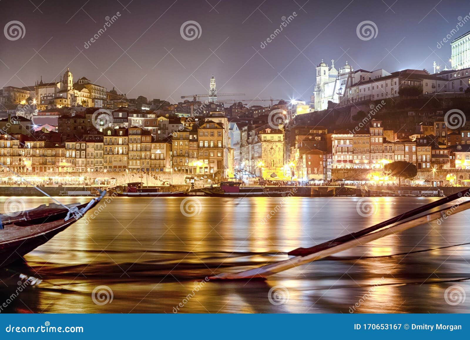 on douro river in porto in portugal at dusk with line of wooden boats