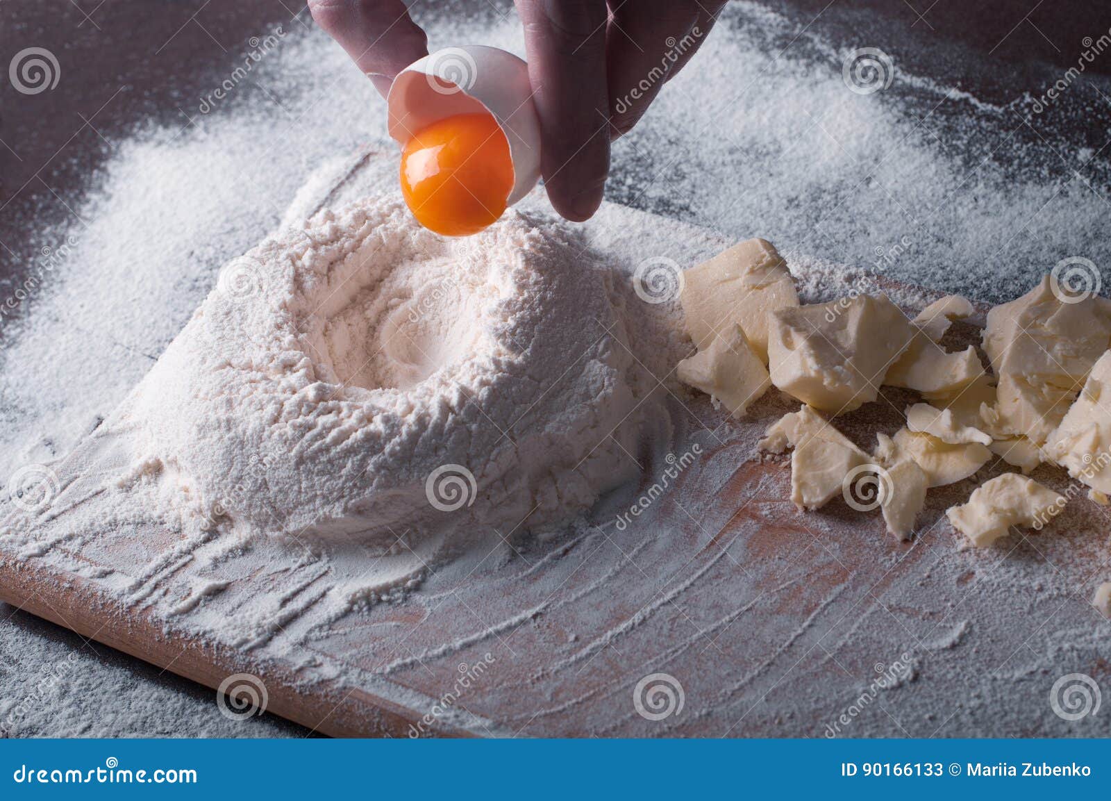 douth, food, cooking concept - preparing douth - cooking progress and ingridients, chef pours egg yolk from eggshell into flour