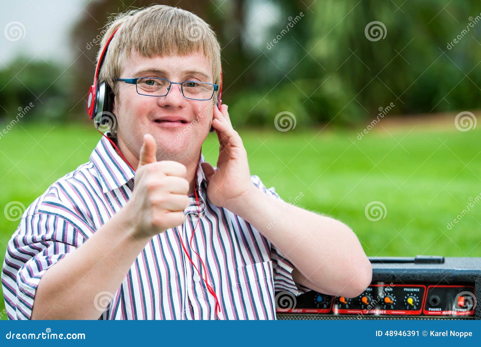 down syndrome boy with headset doing thumbs up.