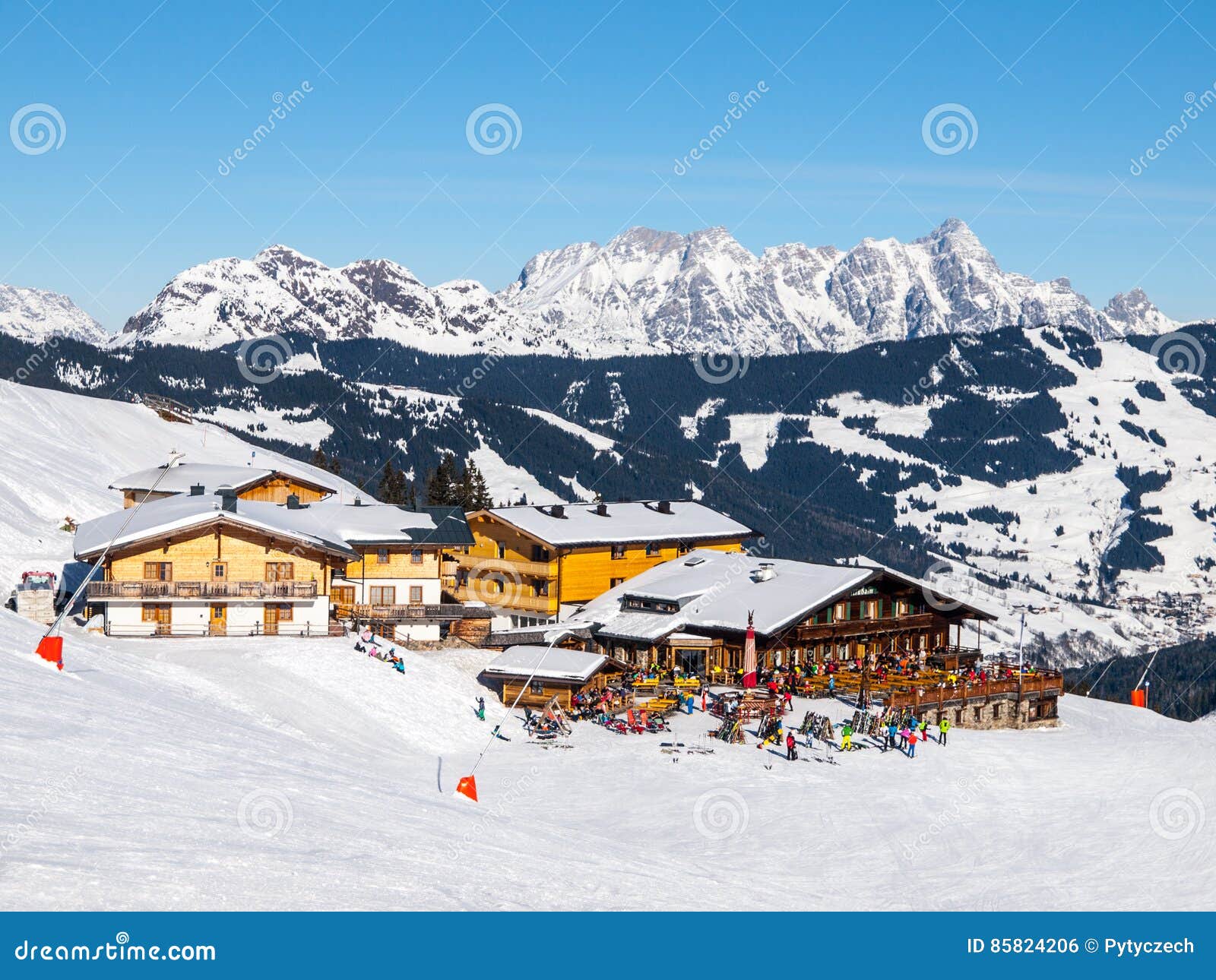 downhill slope and apres ski mountain hut with restaurant terrace in saalbach hinterglemm leogang winter resort, tirol