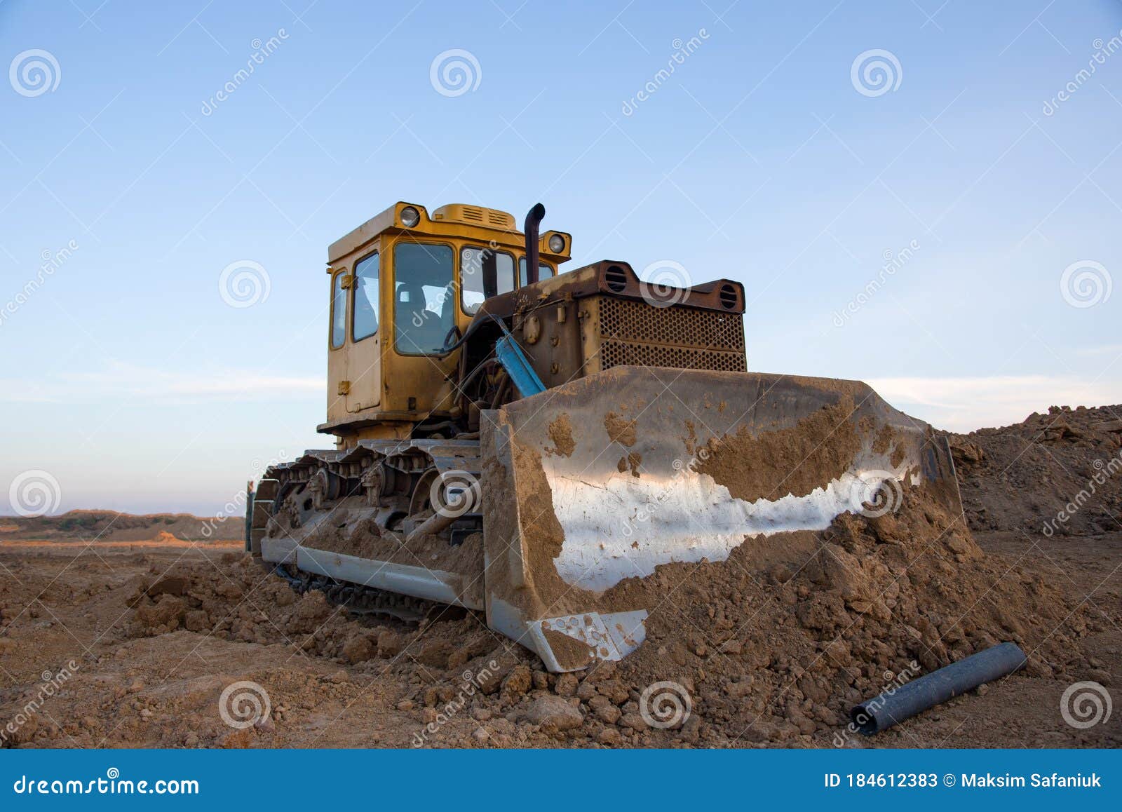 dozer at open pit mining on sunseet background. bulldozer for land clearing, grading, pool excavation, utility trenching and