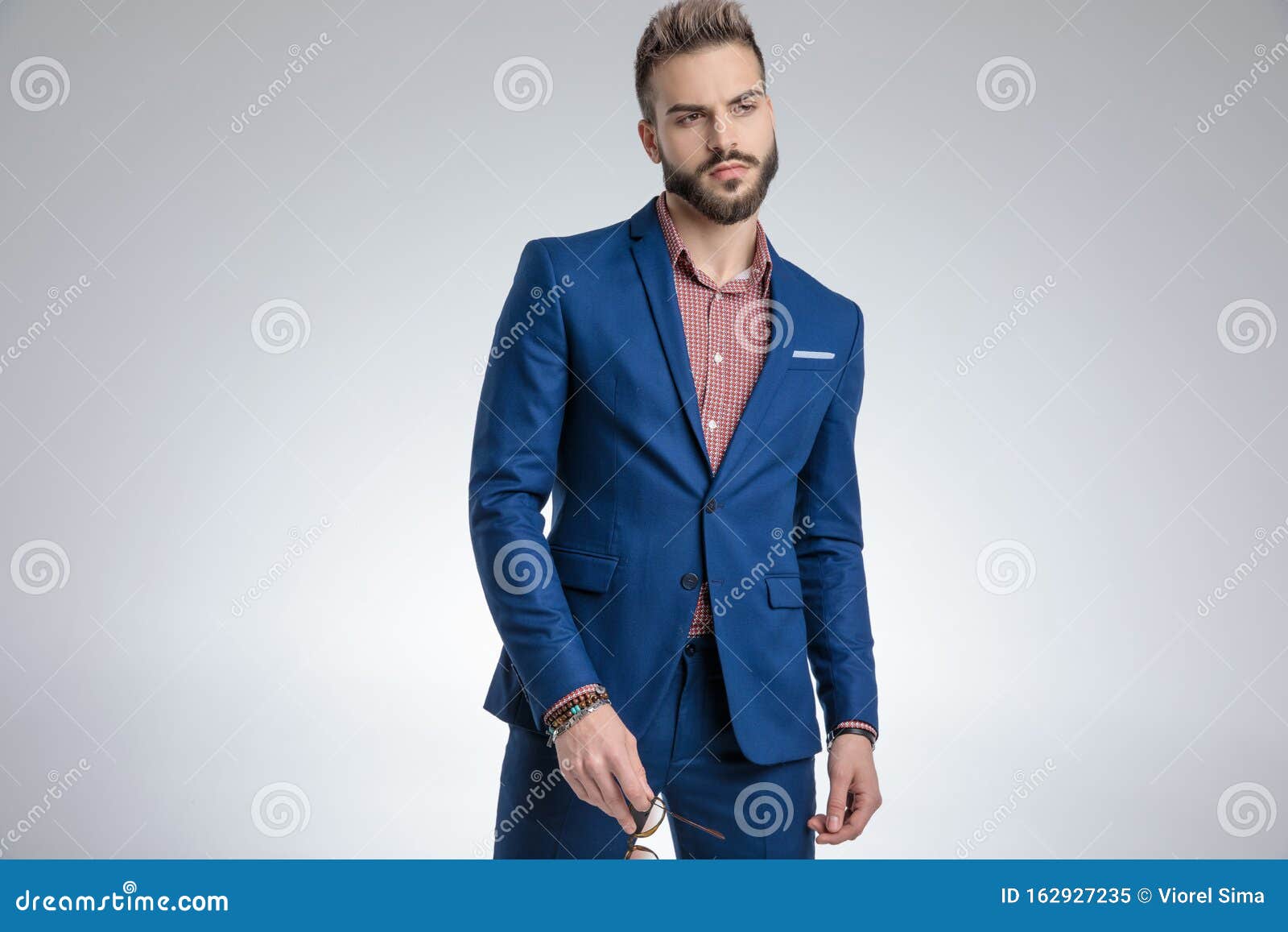 Dramatic Cool Guy in Blue Suit Posing and Holding Sunglasses Stock ...