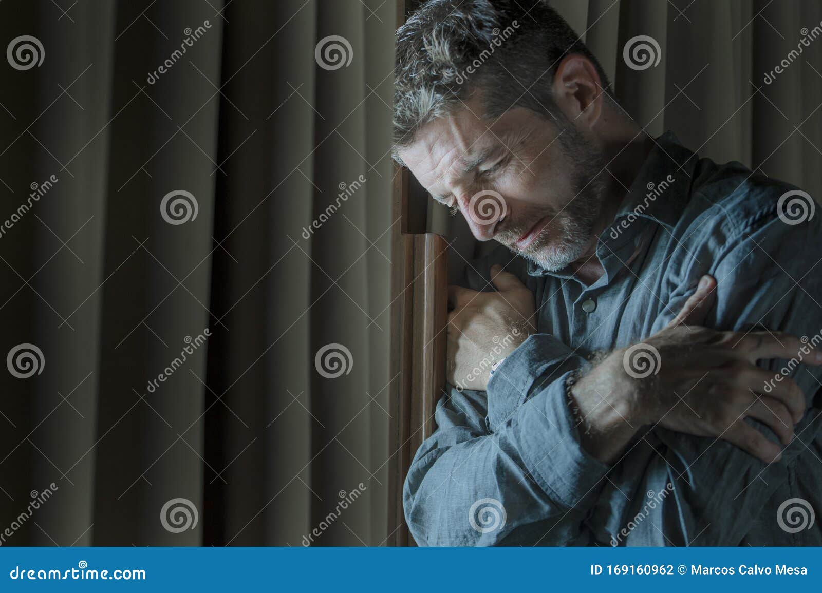 dramatic portrait of depressed and sick man suffering from psychosis illness or mental disorder looking weird and helpless in