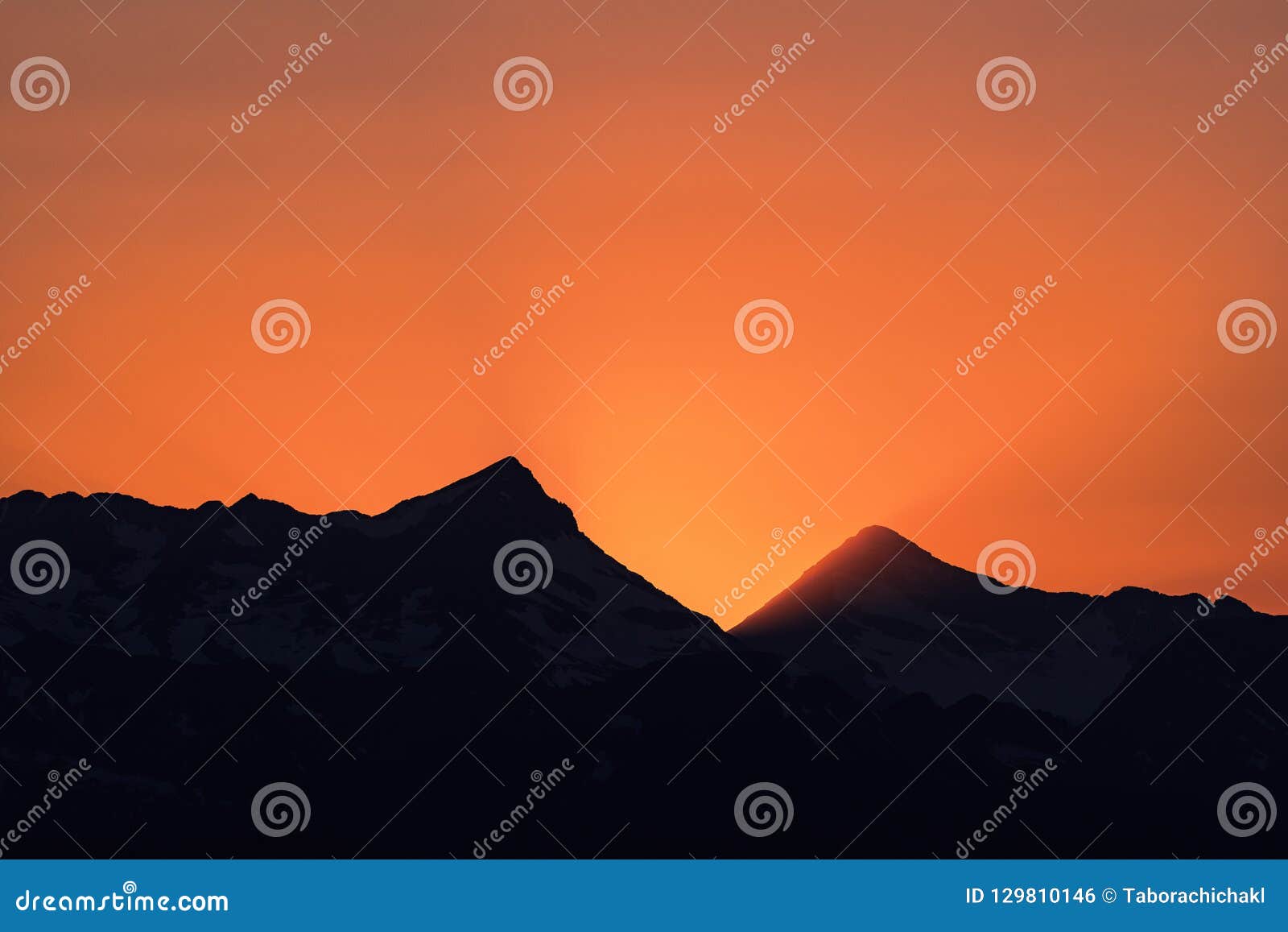dramatic sun rays behind heaven`s peak, glacier national park, montana