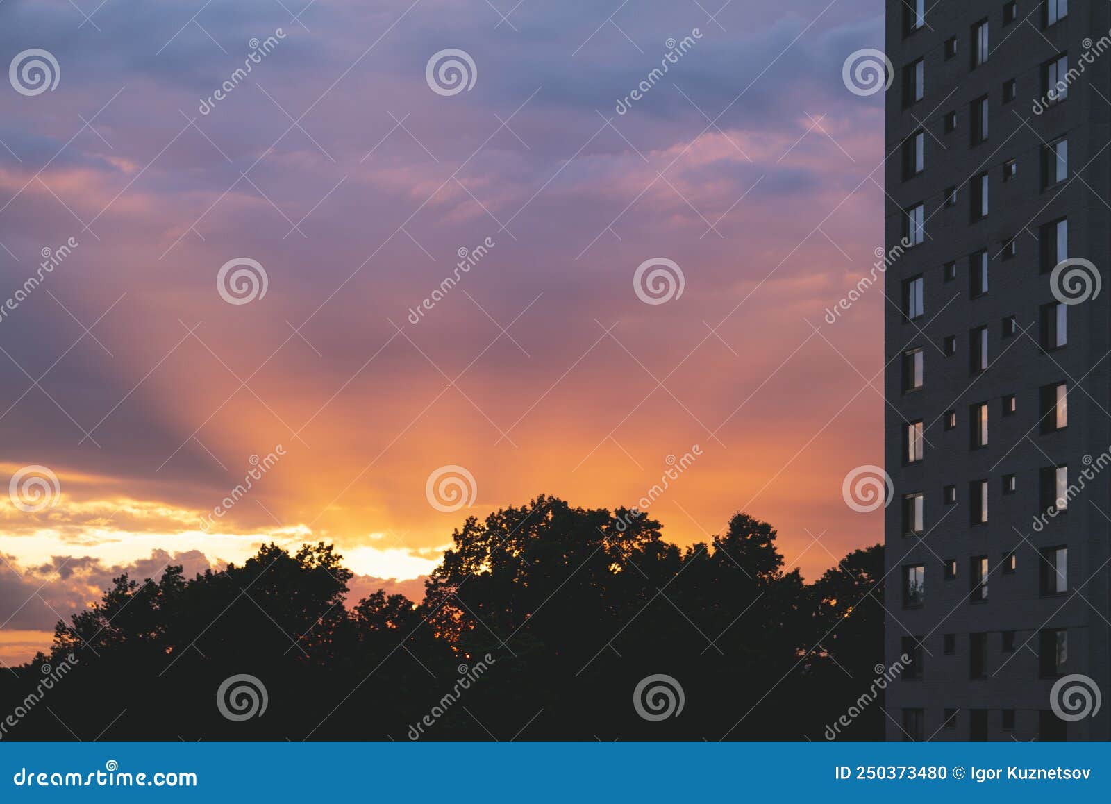 dramatic sunbeams behind the residential building with reflections in a windows, background photo