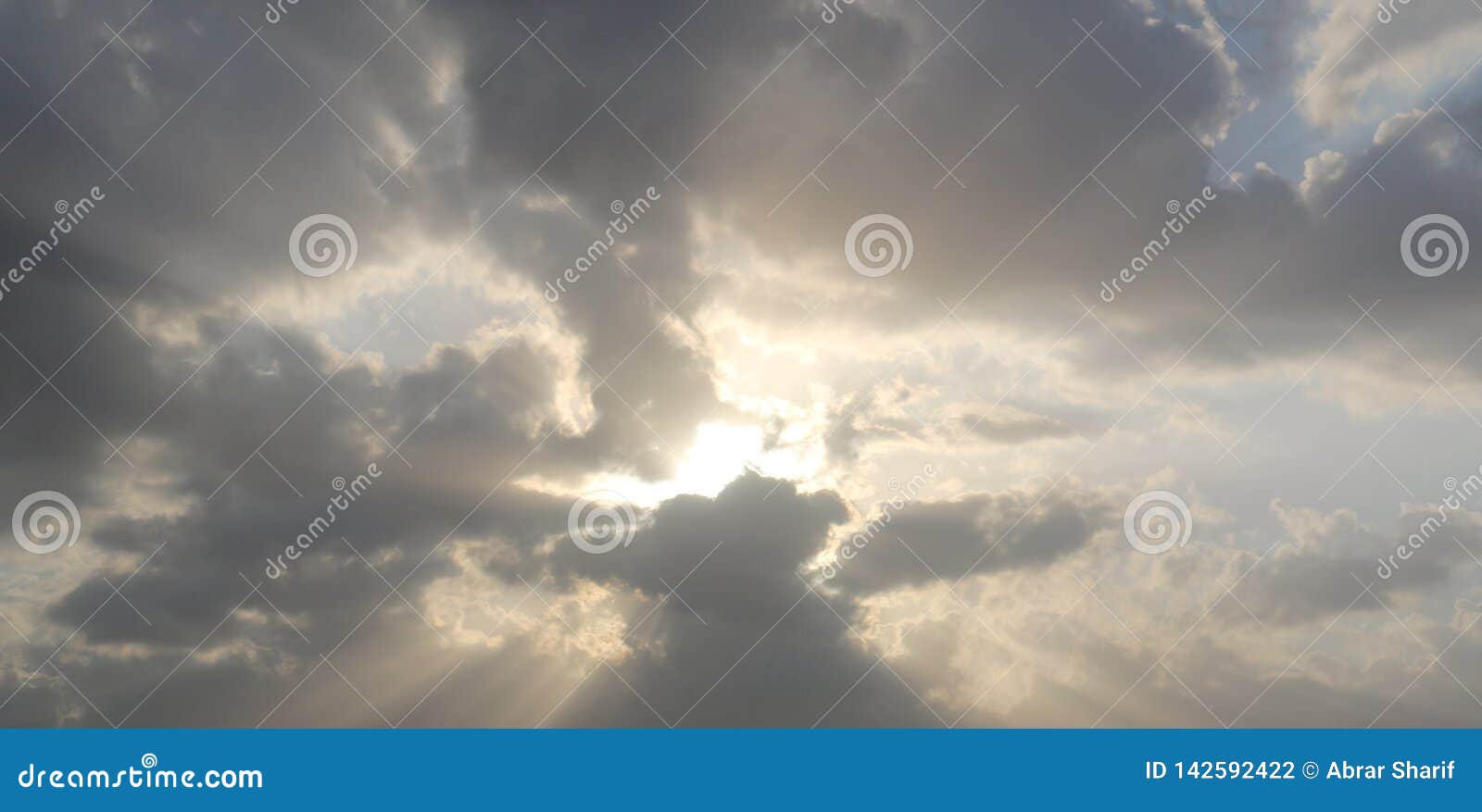 Dramatic blue cloudy sky with white sun rays breaking through the clouds over Dubai, UAE. Nature background. Hope concept.