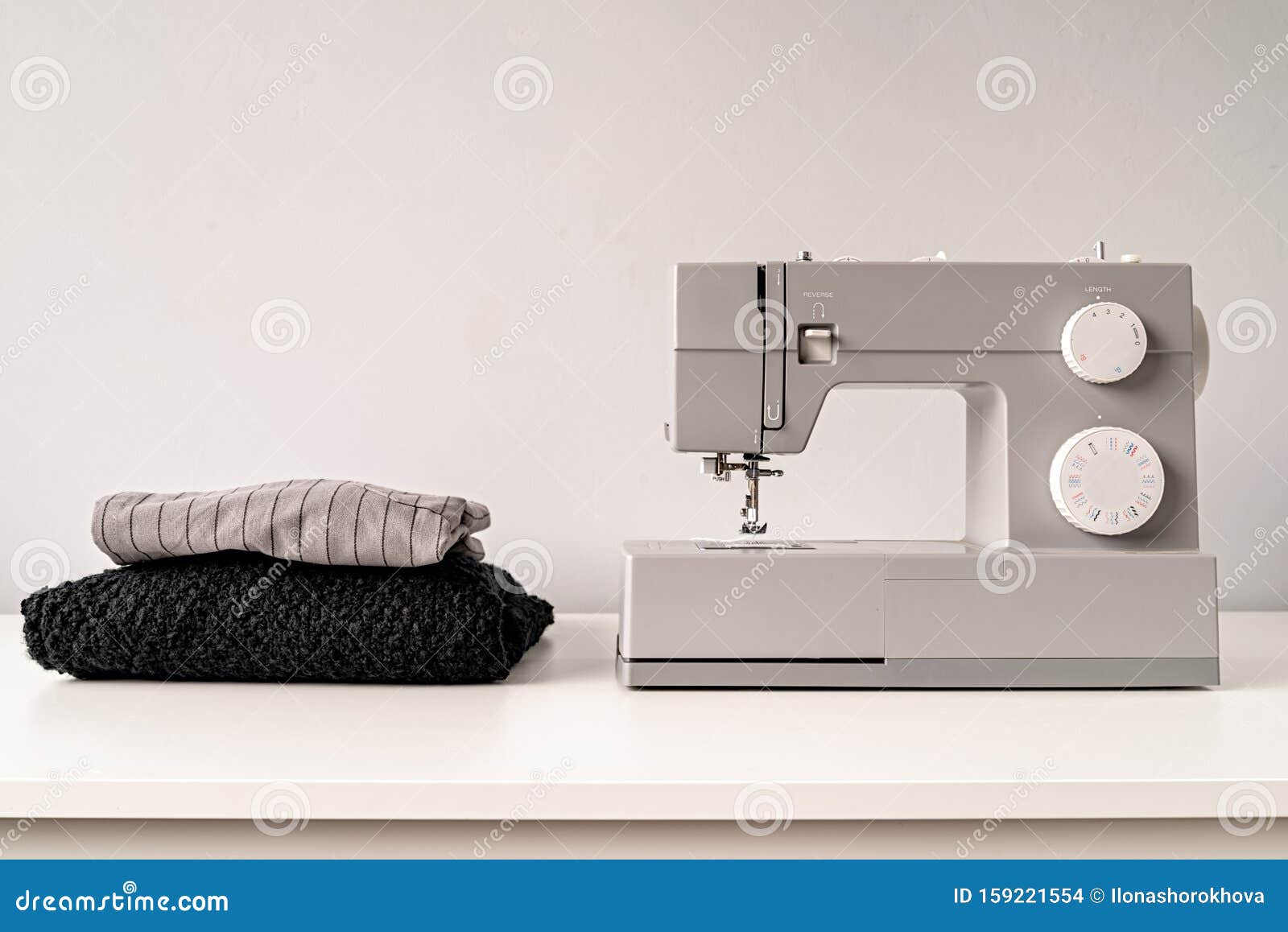 Sewing Machine on Tailor Table with Fabric with Copy Space Stock Photo