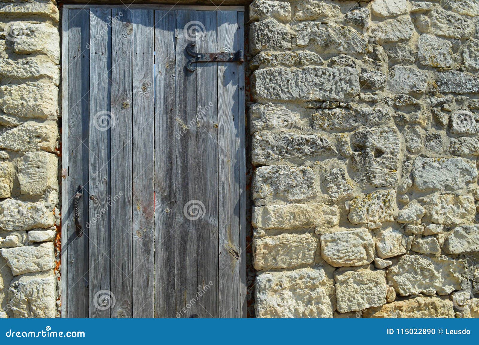 Drewniany drzwi z metali zawiasami instaluje w ścianie antyczny kamień - co kryje ono?