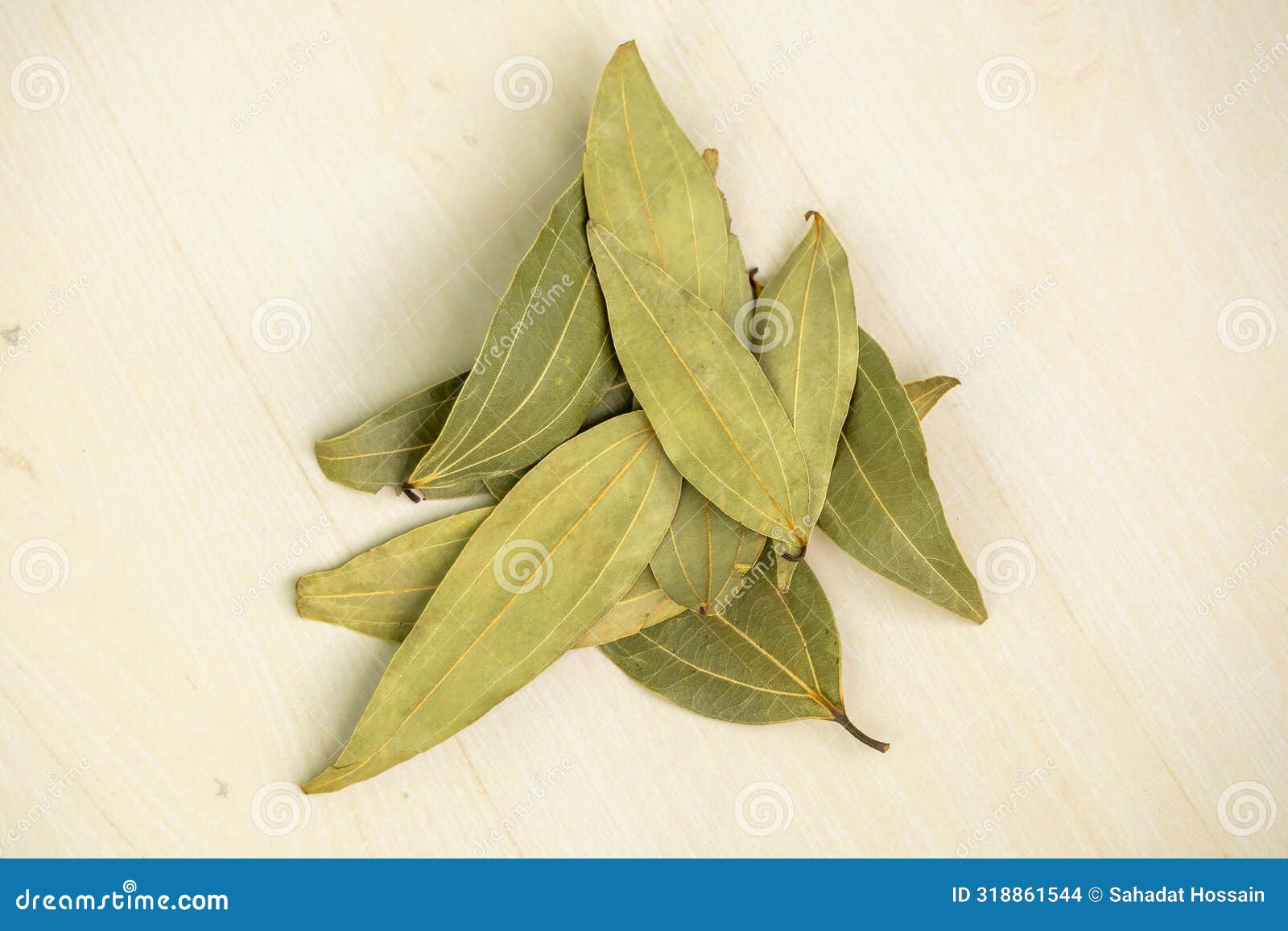 dried bay leaves  on a wooden background. bay leaf is a good source of vitamin a, vitamin b6, and vitamin c.