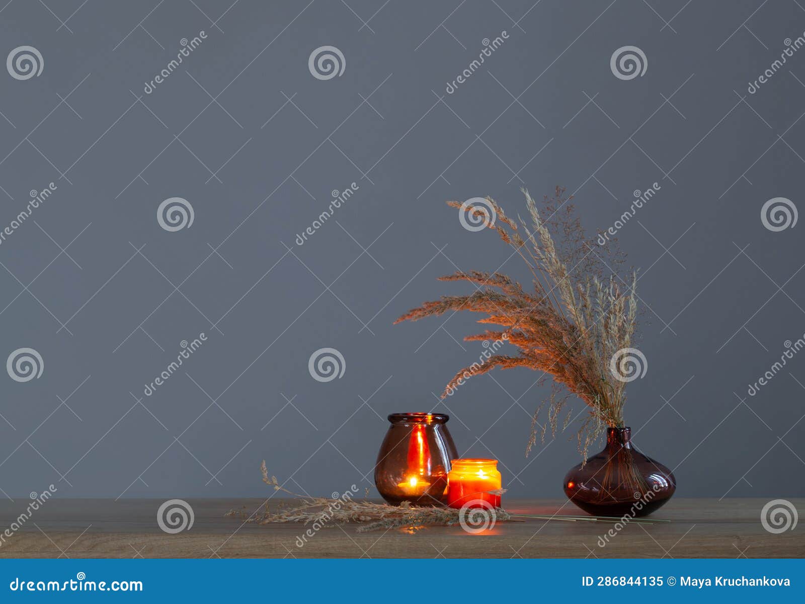 Dried Flowers and Burning Candles on Background Dark Wall Stock Image