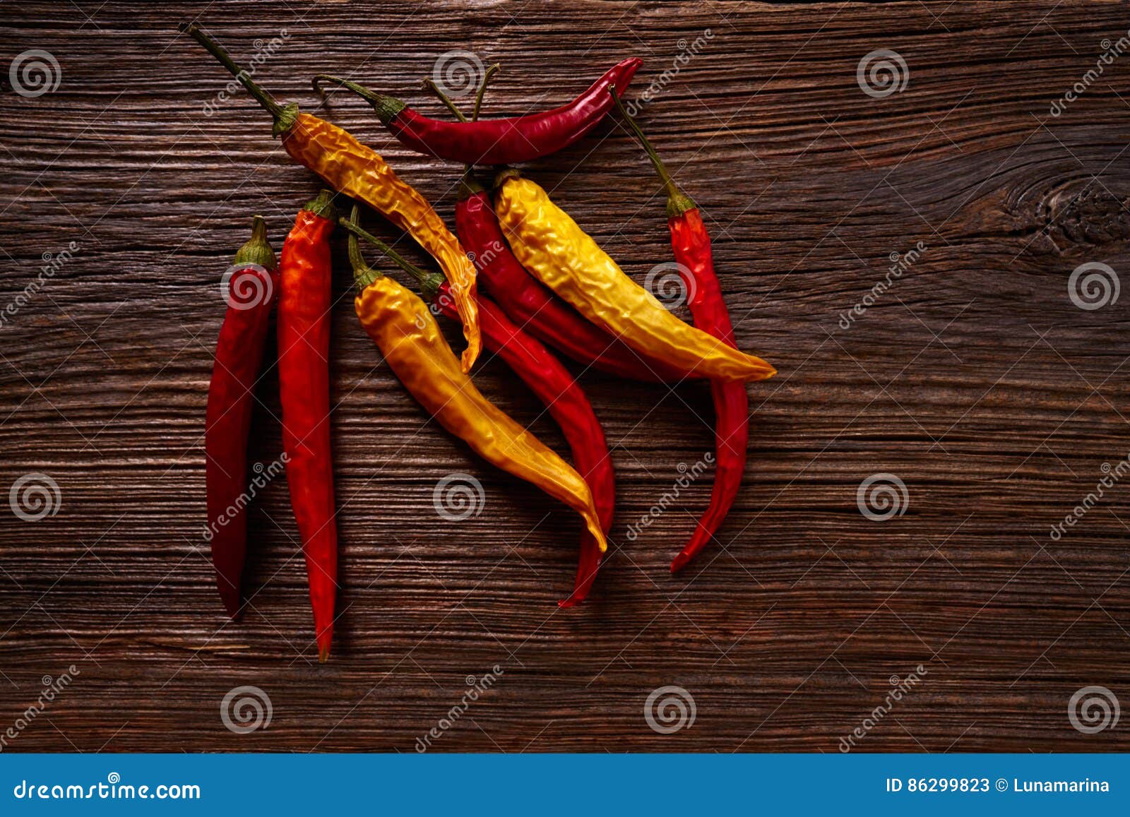 dried hot chili peppers on aged wood