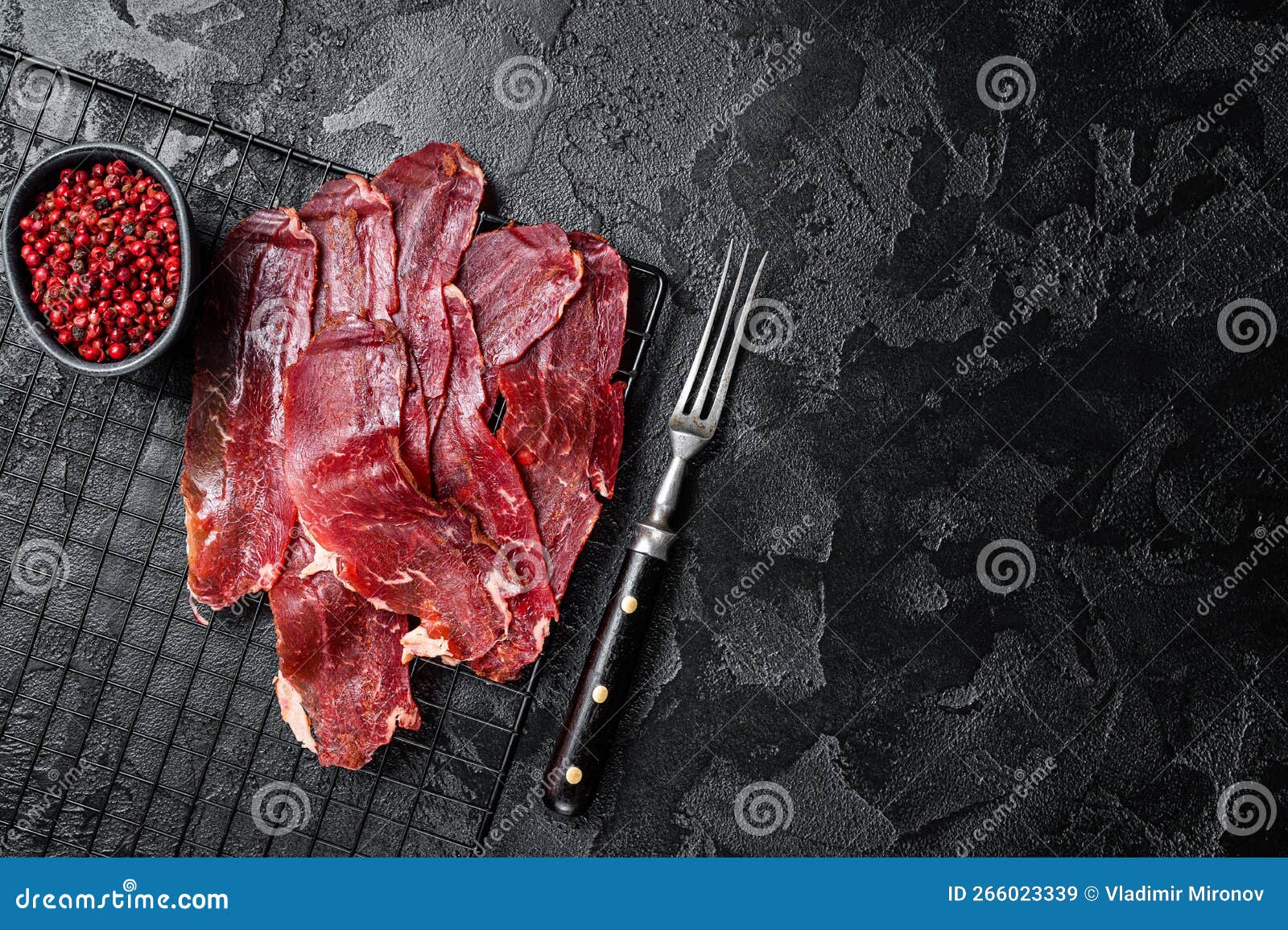 dried sliced basturma, cured beef meat ready for eat. black background. top view. copy space